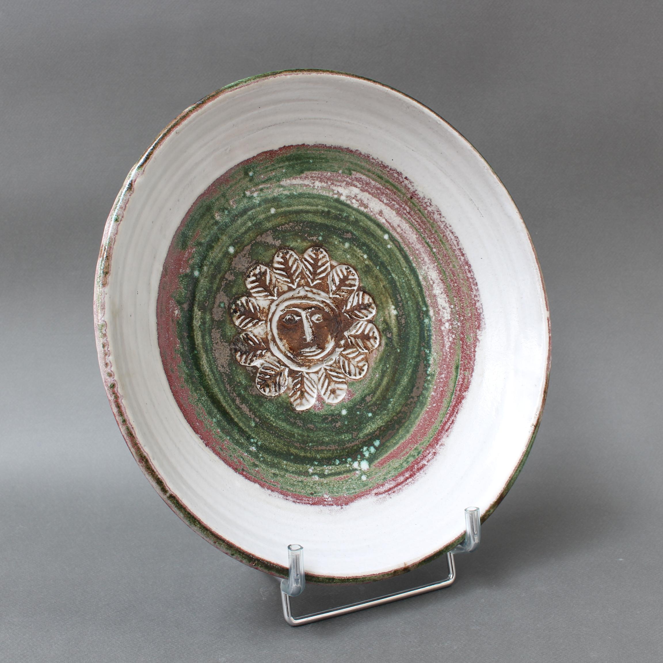 Mid-century decorative platter (circa 1960s) by Albert Thiry (1932-2009). A whitened glaze encircles a deeply engraved sunflower motif (with face) in brown and highlighted by forest green and mulberry coloured concentric circles. Rustic yet