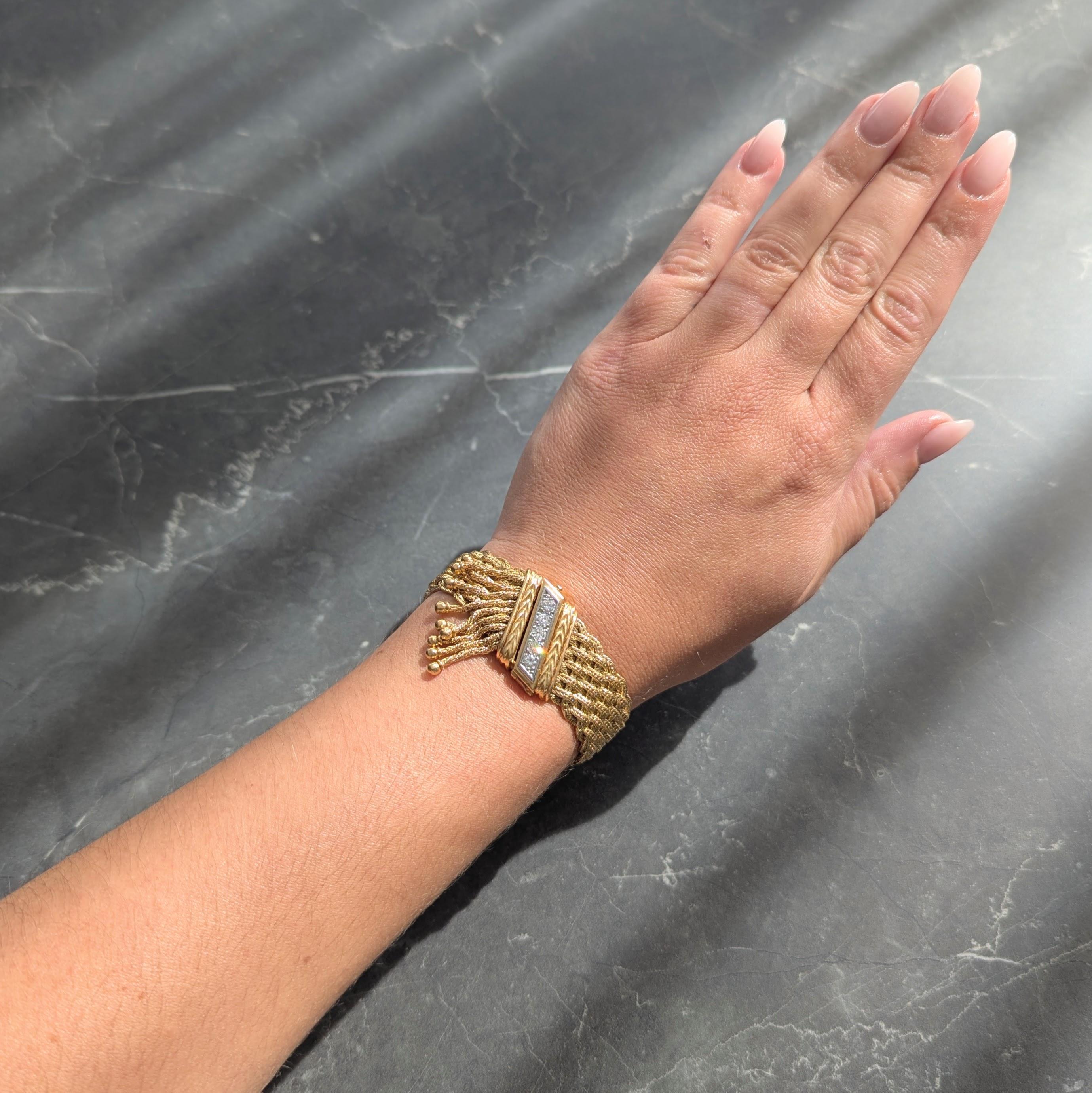 Conçu comme une chaîne de blé en or jaune dont les brins sont disposés en forme de panier.
Accentué par des terminaisons en or jaune avec un motif de tresse rainurée et une frange de glands.
S'articulant comme une chaîne de blé et se terminant