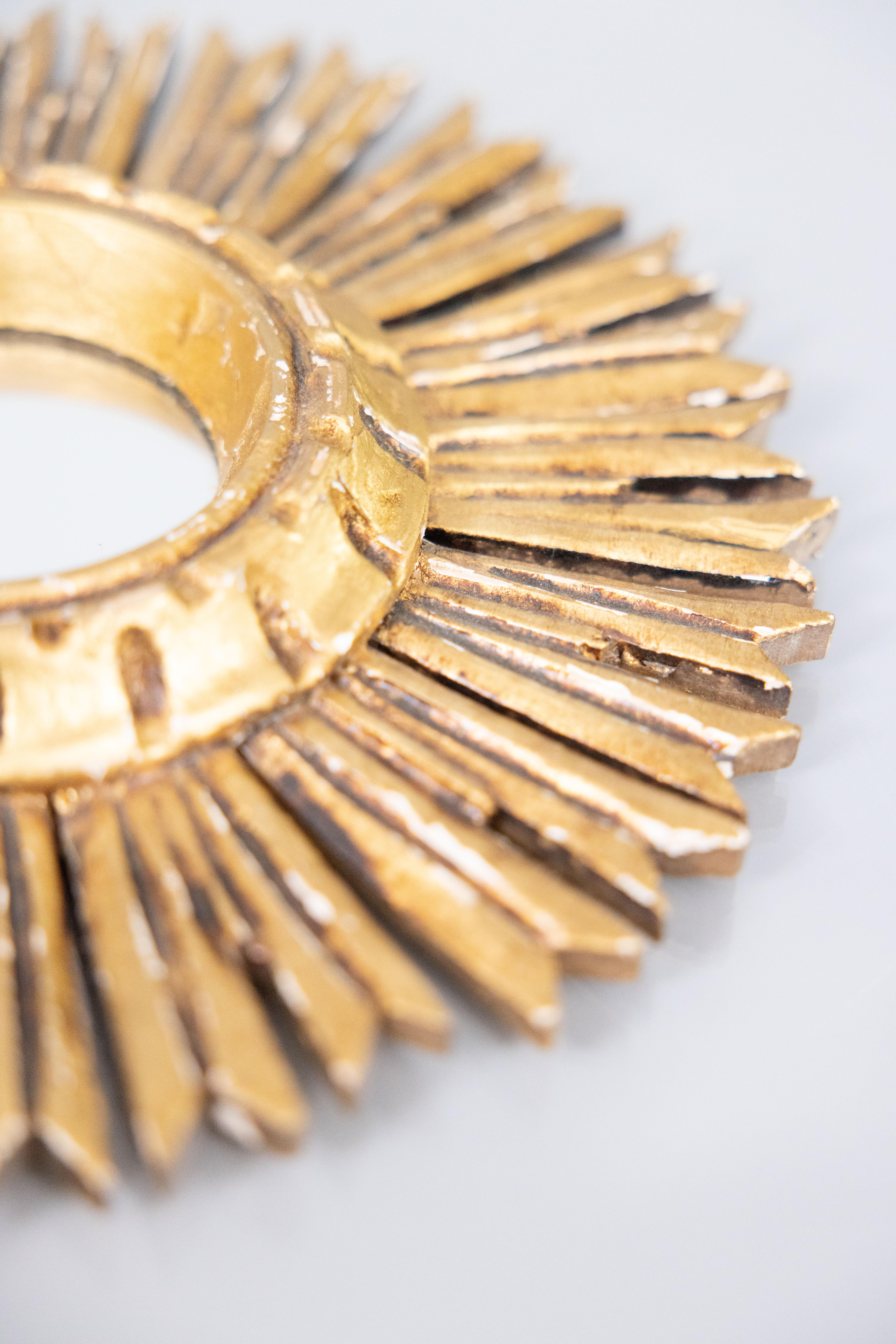 A lovely petite vintage French gilt wood sunburst or starburst mirror, circa 1950. This stylish mirror is surrounded by hand carved rays with a lovely gilt patina.

Dimensions
11ʺW × 1.5ʺD × 11ʺH