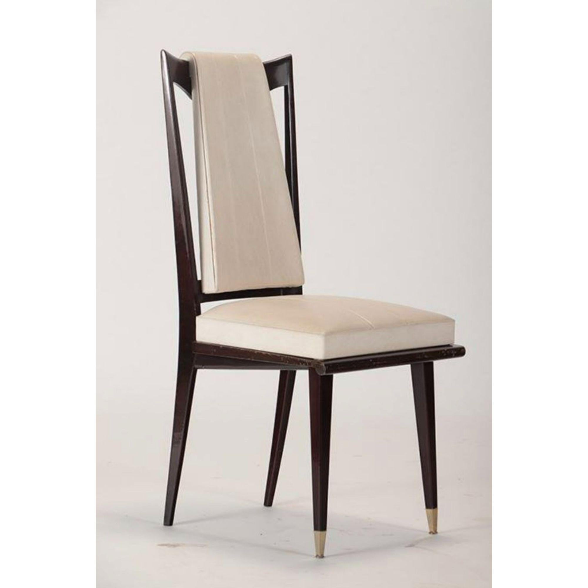 Set of six mid-century French wood and upholstered dining chairs. These stylish chairs are crafted in mahogany wood frames and are upholstered in an off-white vinyl with brass caps on the front tapered legs.