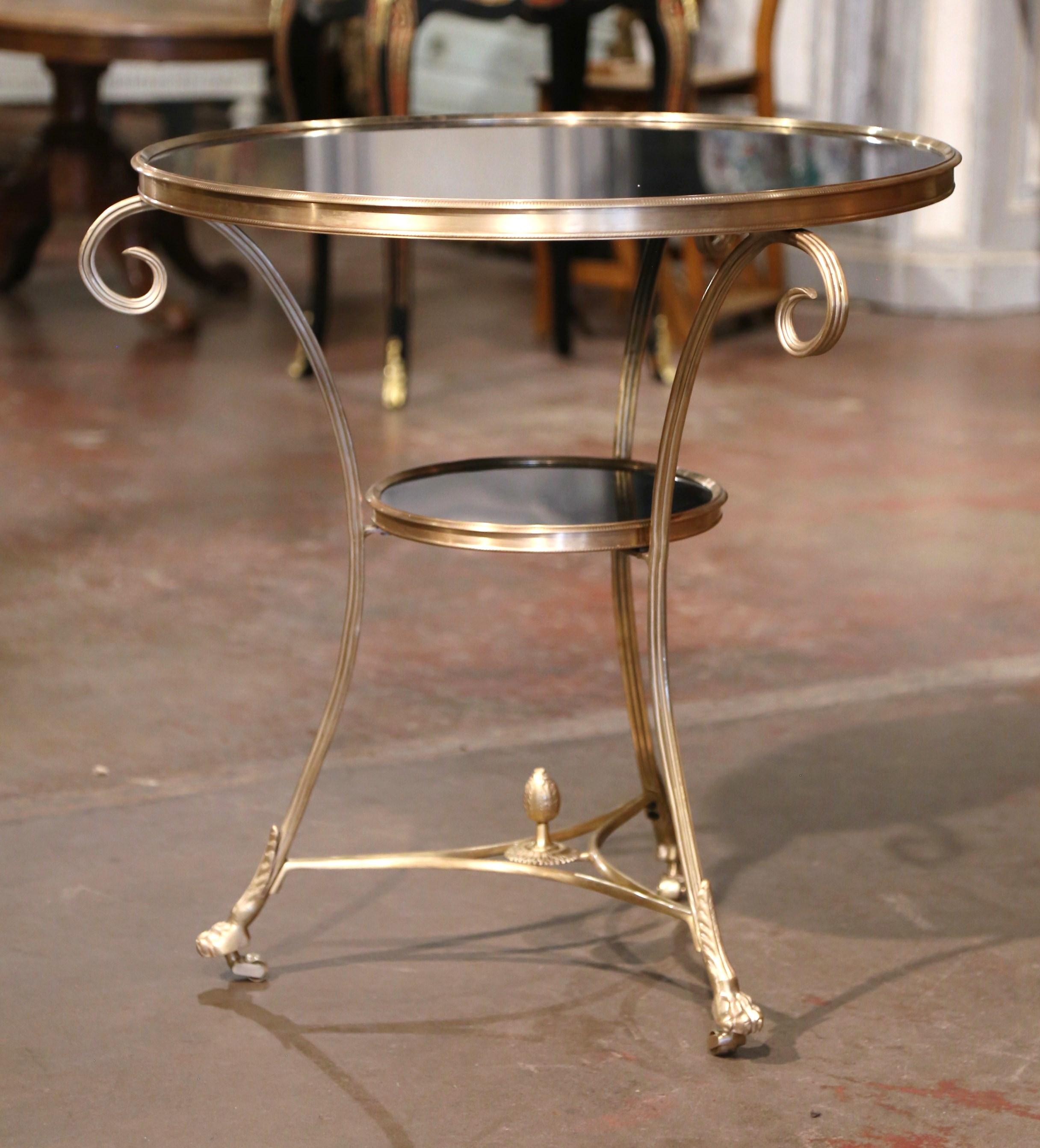 Decorate a living room with this elegant neoclassical antique two-tier gueridon table. Created in France circa 1970, and round in shape, the table is supported by three slender cabriole legs with hoof feet decorated with acanthus leaf motifs, and