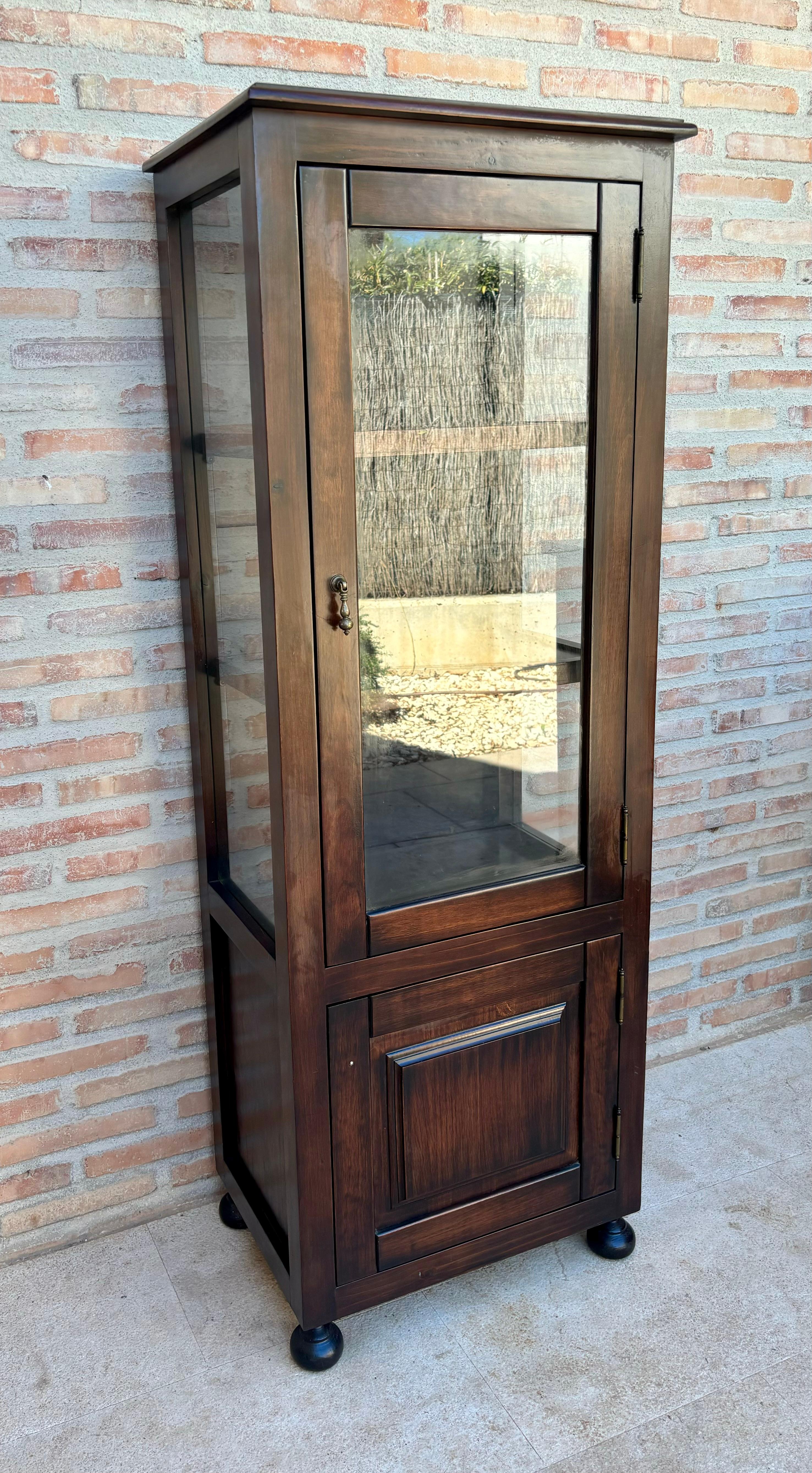 Elegante vetrina di design francese degli anni '50, con pannelli nella parte inferiore del mobile, con una maniglia originale in bronzo sulla porta d'ingresso in vetro.
Ha tre ripiani in legno, tutti affiancati da montanti, su gambe arrotondate.