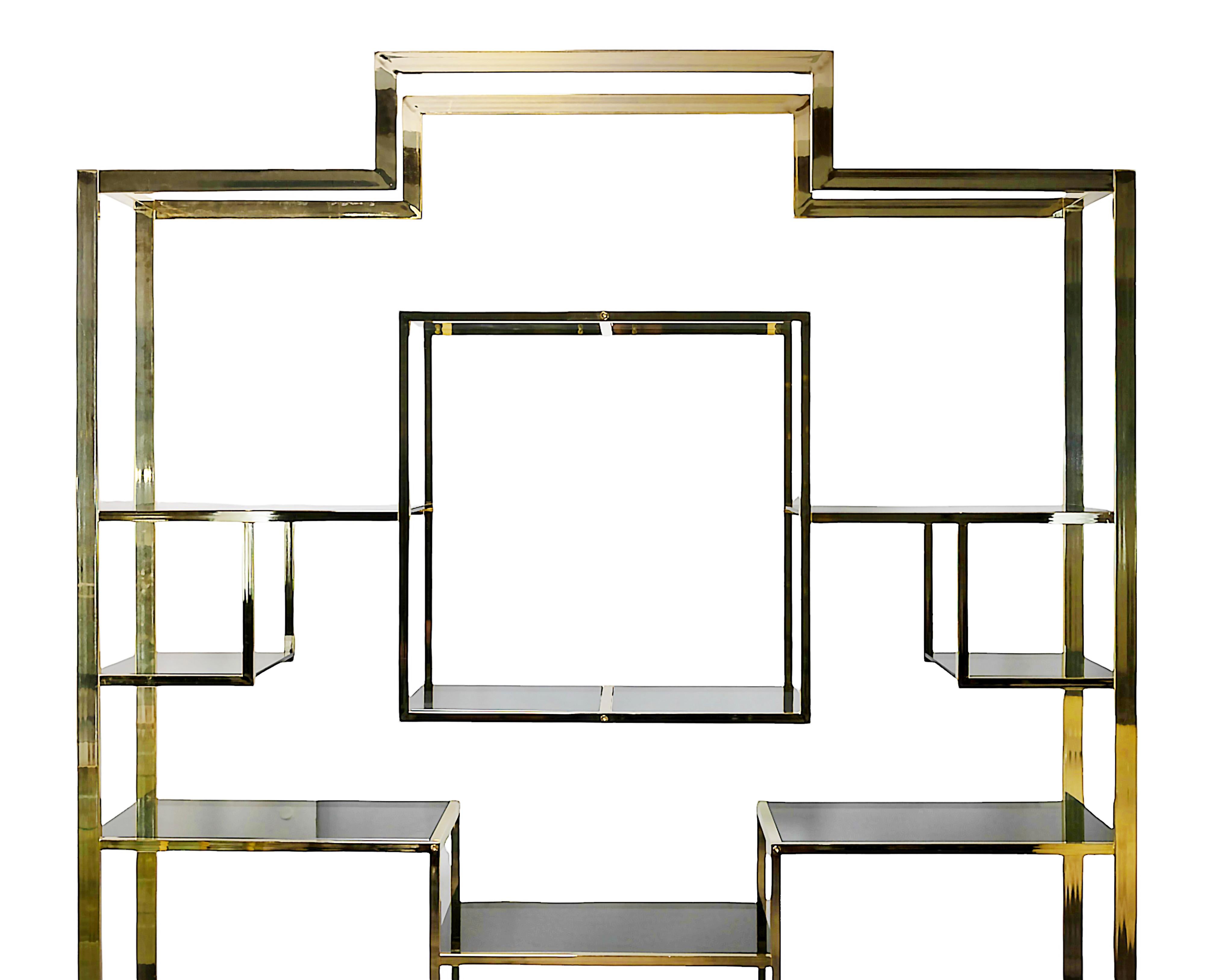 Französische vergoldete Metall-/Stahl-Etagere/Bücherschrank von Kim Moltzer aus der Mitte des Jahrhunderts (1970er Jahre).
Die Struktur ist in quadratischer Form vergoldetem Stahl mit Regalen aus rauchigem Glas auf schwarzer Farbe Basis.
In sehr