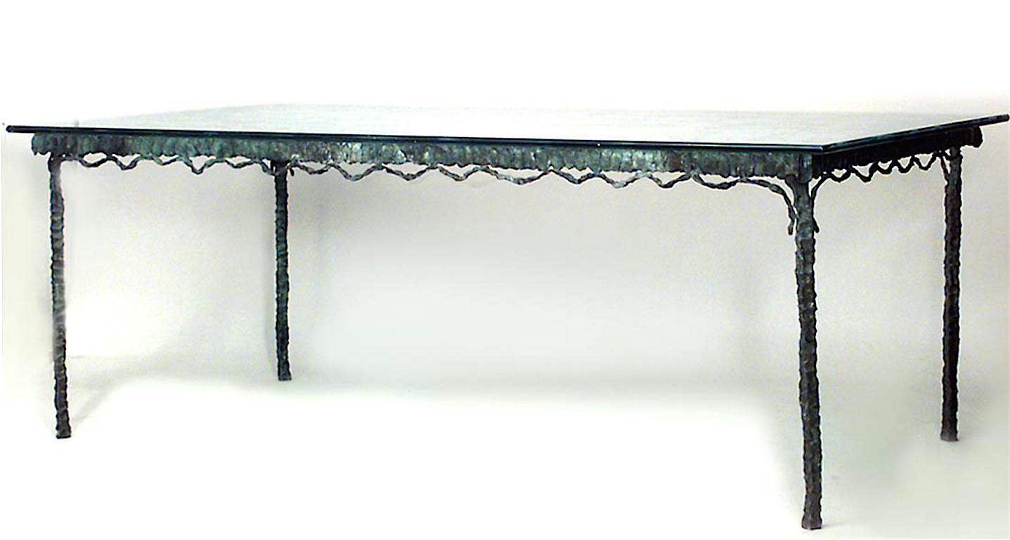 1960s or 1970s French dining table with a textured, verdigris patinated bronze base with four narrow legs and a stylized swag apron. The rectangular glass top features a painterly etched heart pattern.