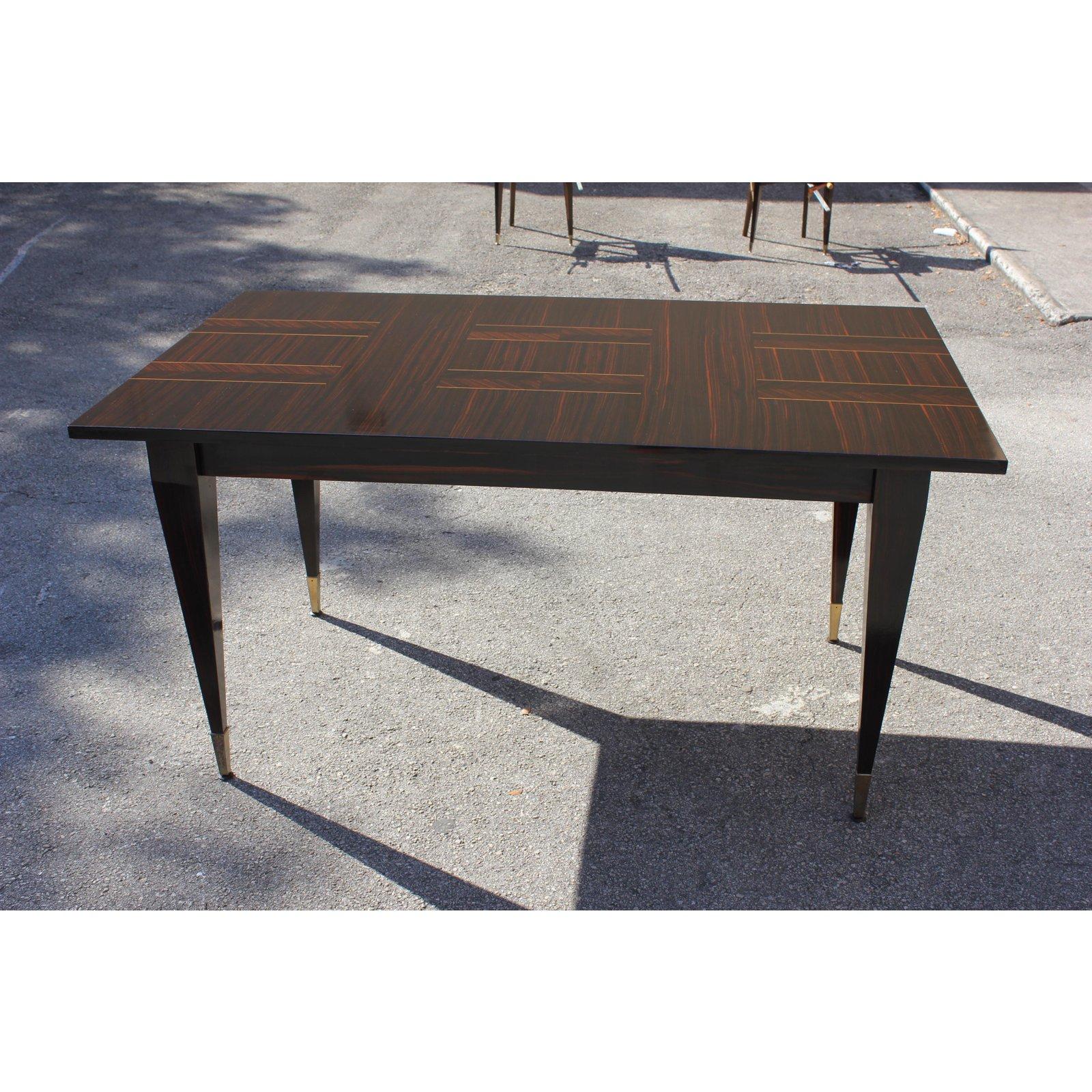 Stunning midcentury French exotic Macassar ebony dining table or writing desks. Solid Macassar ebony wood legs with brass hardware caps. Very nice centre Macassar design top. Dimensions: H 30 in. x W 59.13 in. x D 35.50. We traveled to buy all our