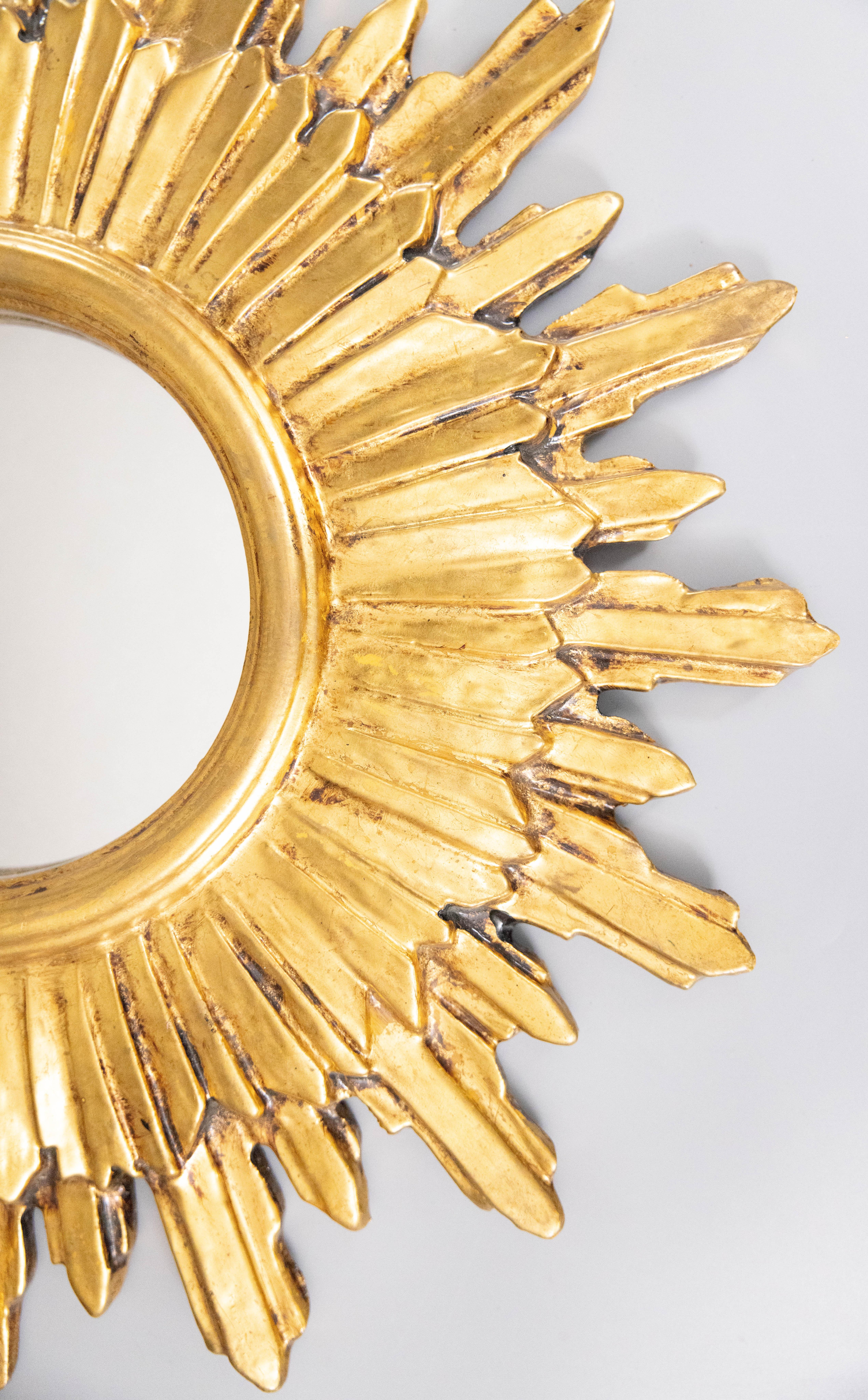Superbe miroir en bois doré et gesso, vers 1950. Ce miroir élégant est entouré de jolis rayons de longueurs alternées avec une belle patine dorée. 

Dimensions
20,25ʺW × 1,5ʺD × 20ʺH