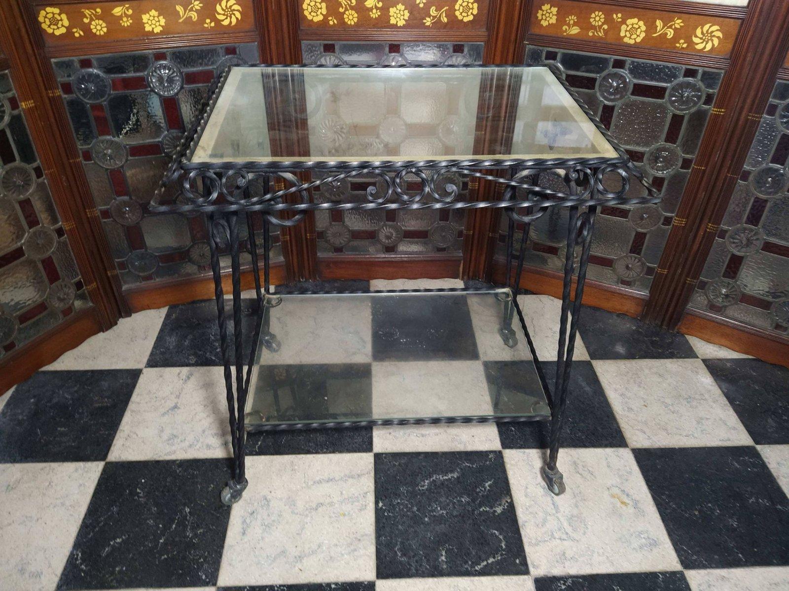A Mid Century French Glass & Wrought Iron Two Tier Tea or dessert Trolley on castors with decorative hand-worked scrollwork details.