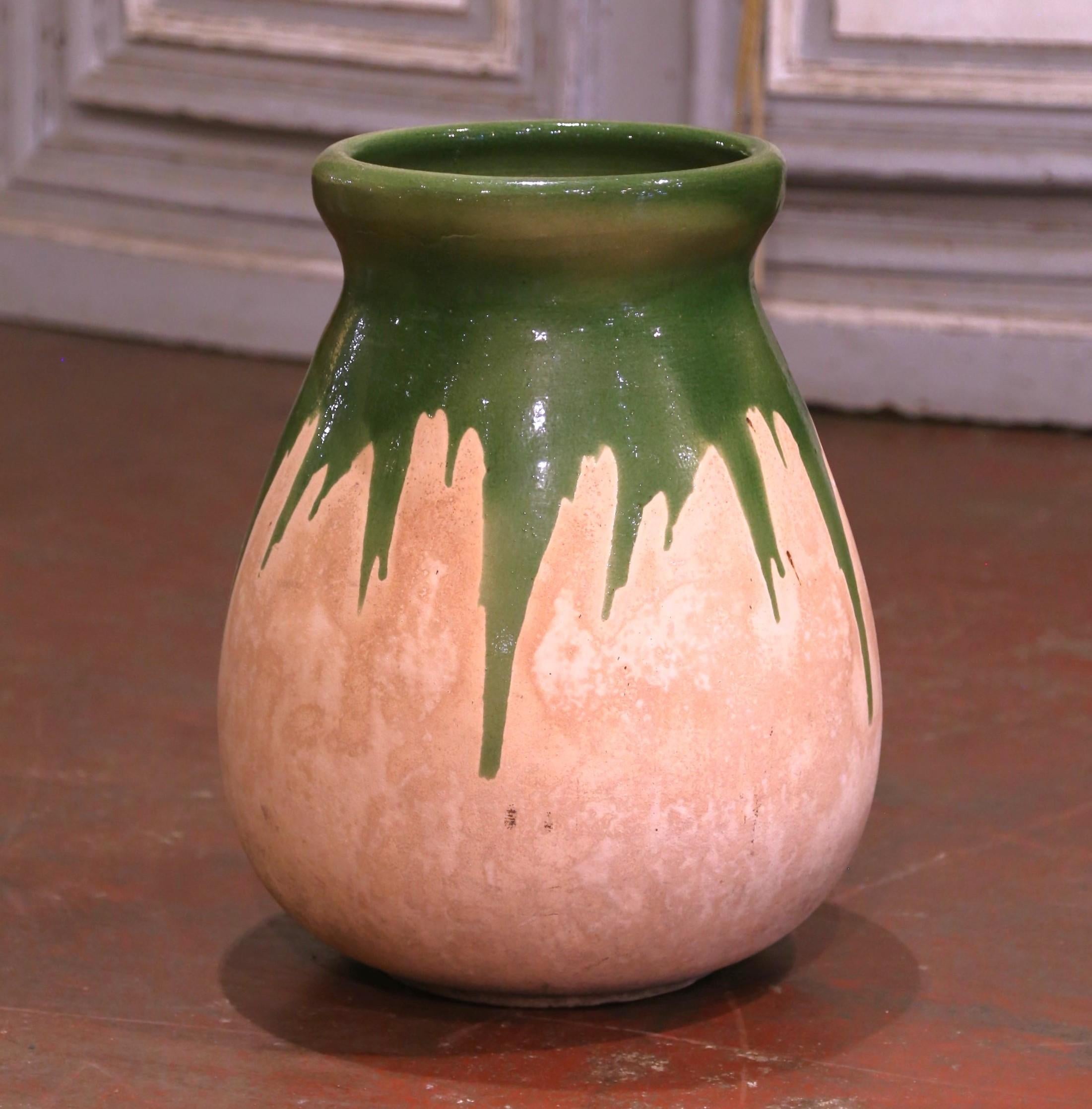 Questo antico vaso per olio d'oliva in terracotta è stato creato nel Southern France, intorno al 1950. Realizzato in argilla bionda e di colore verde intenso, il vaso in terracotta ha una tradizionale forma rotonda. La pentola rustica e consumata