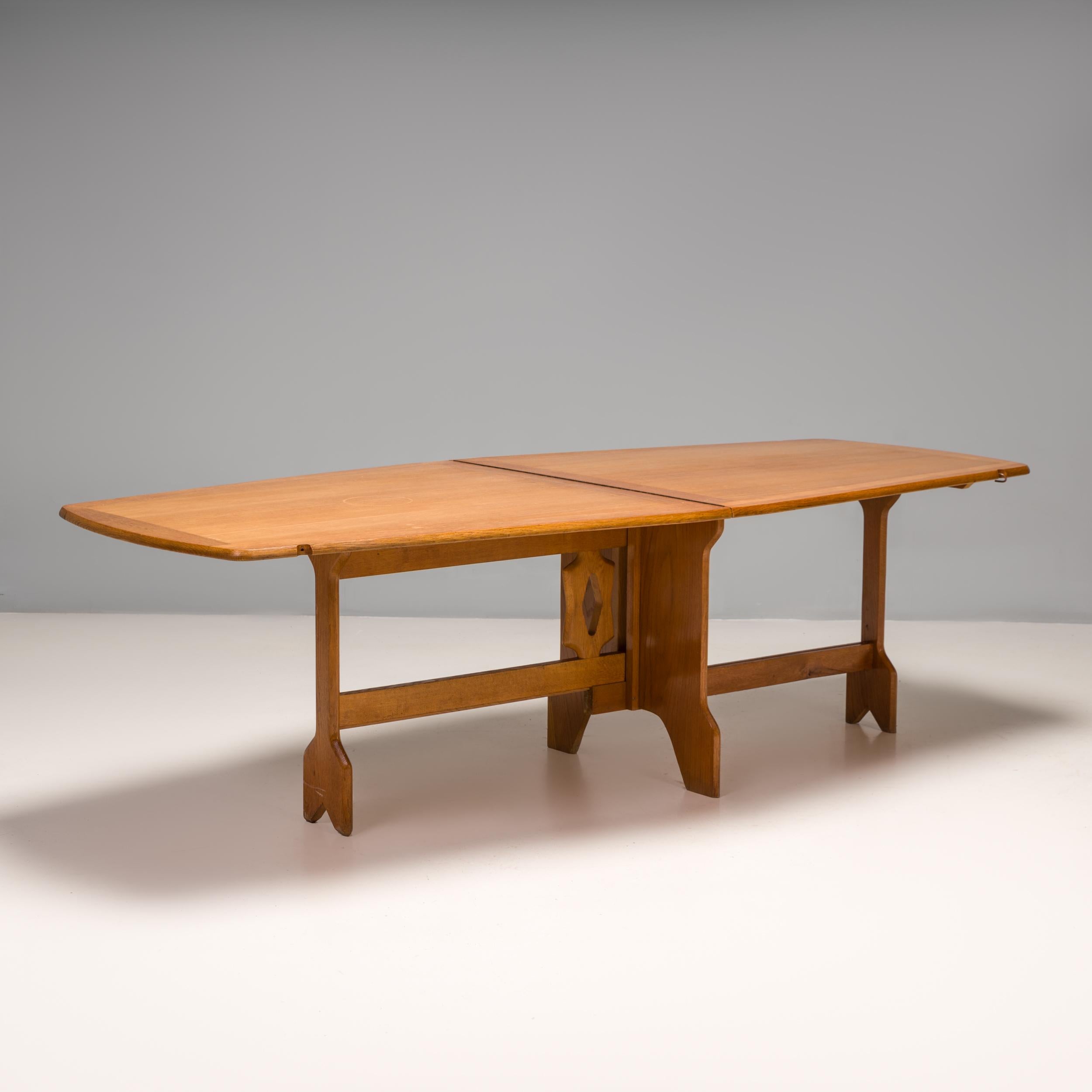 Designed by Robert Guillerme and Jacques Chambron, this folding dining table is a fantastic example of the pair’s sculptural design style in post war France.

Constructed from solid oak, the table has a slightly angled shape and is hinged down the