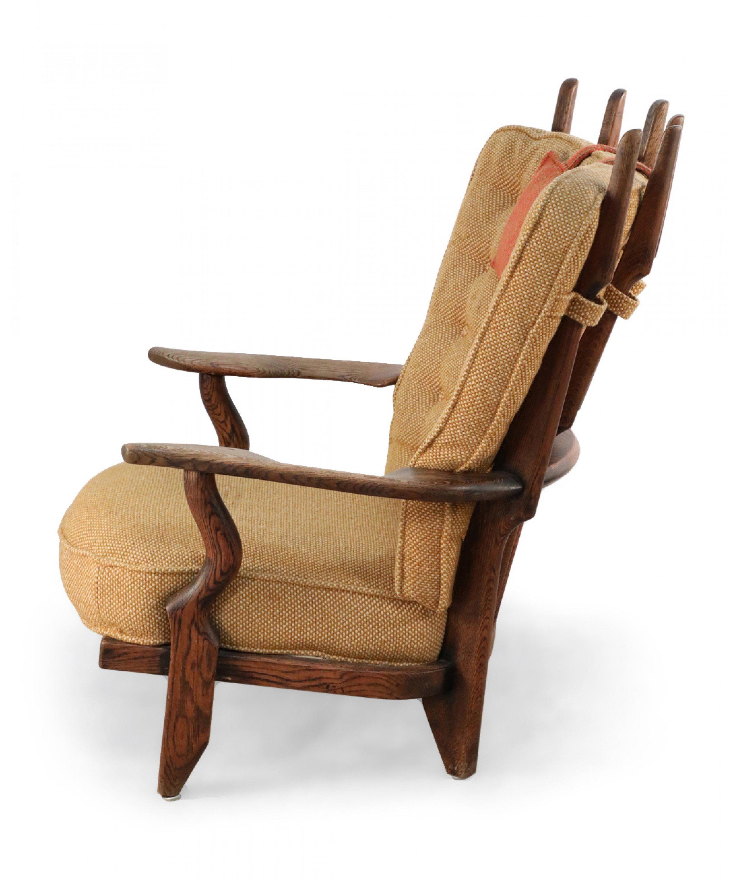 Mid-century French oak armchair with six fanning back slats and beige button tufted upholstery with an orange head cushion (Guillerme et Chambron).