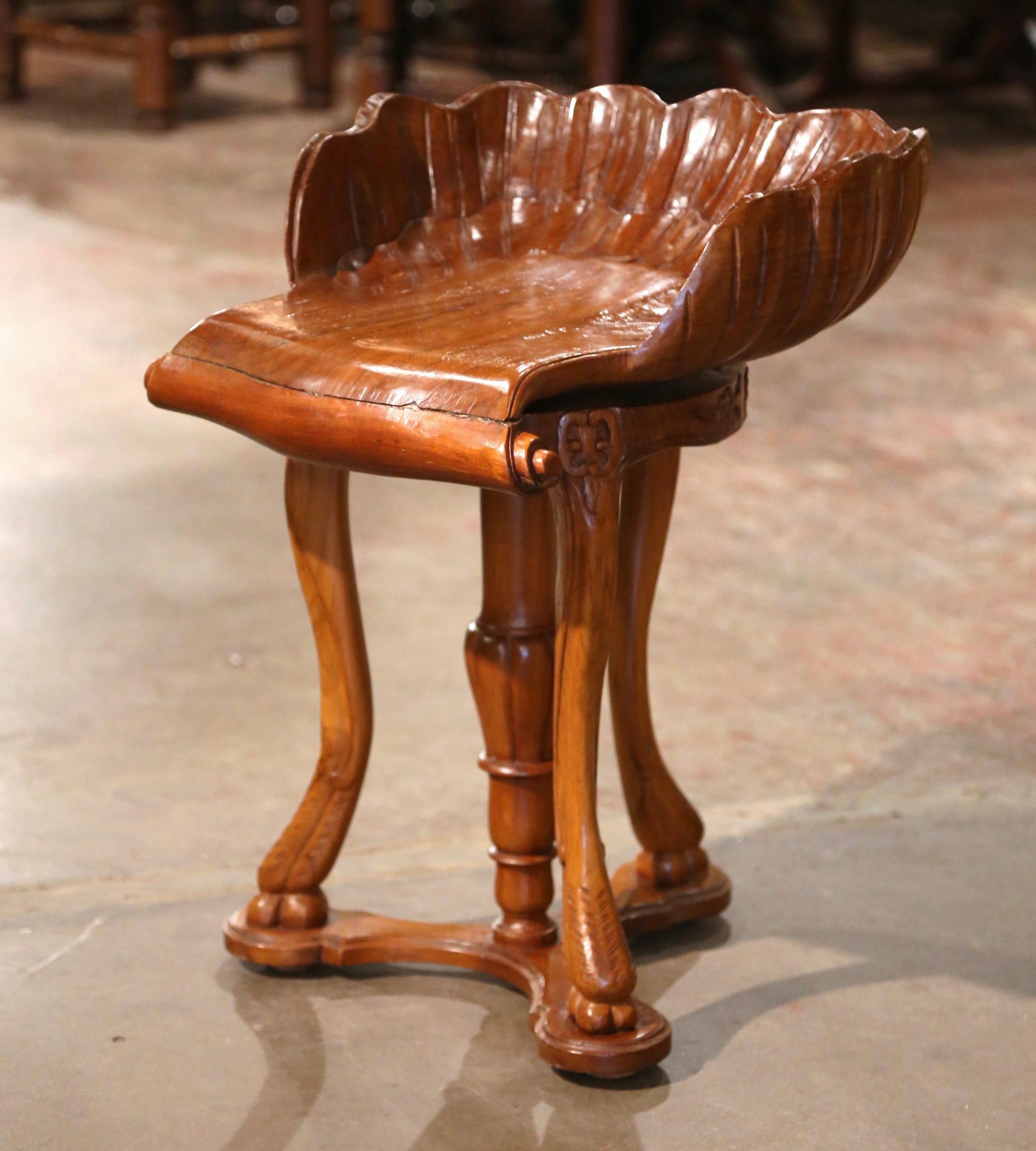 This carved antique fruitwood grotto stool was created in France, circa 1950. Perfect as a piano stool or simply a statement piece, the bench, built of chestnut wood, stands on cabriole legs joined with bottom stretcher, and ending in animal paws