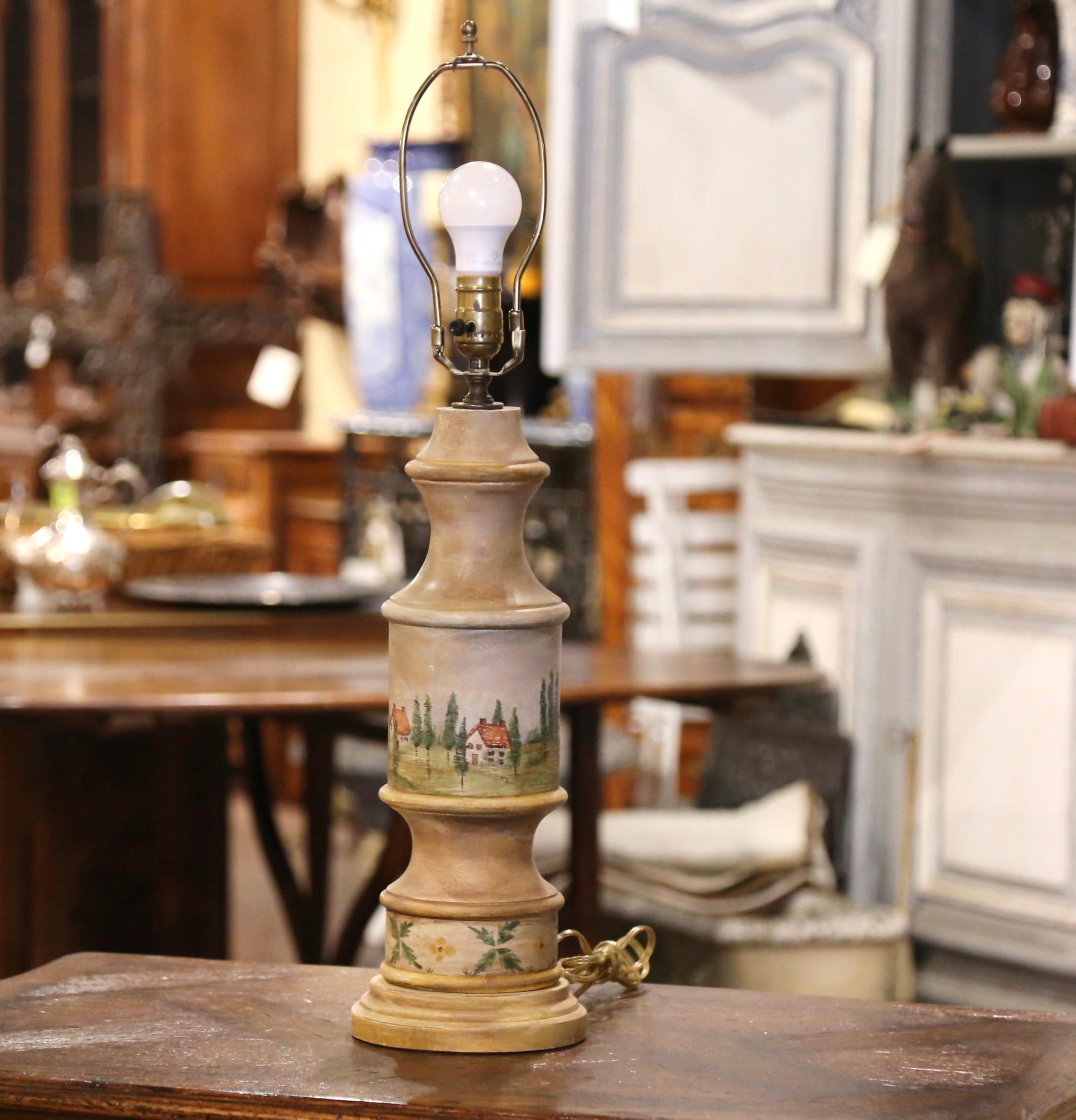Decorate a desk or buffet with this colorful antique lamp. Crafted in southern France circa 1960, the hand carved table lamp features hand painted pastoral scenes with farmhouses and landscapes. The light is in excellent condition and adorns