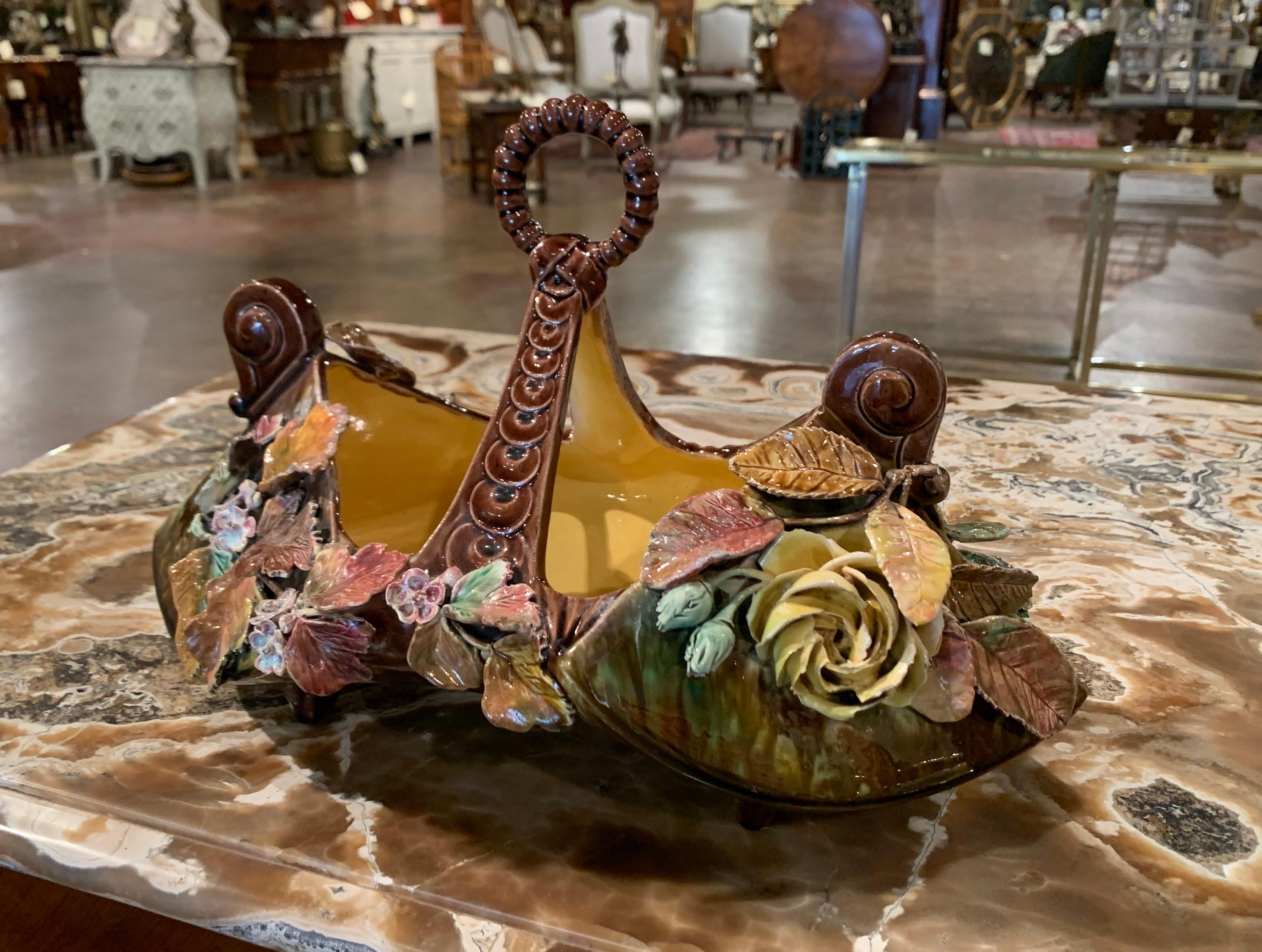 Diese elegante antike Vase aus Majolika wurde um 1950 in Frankreich hergestellt. Dieser farbenfrohe Übertopf hat ein traditionelles, handbemaltes Dekor, das mit Hochreliefblumen und Blättern in Braun, Mauve, Beige und Rosa auf dunkelgrünem