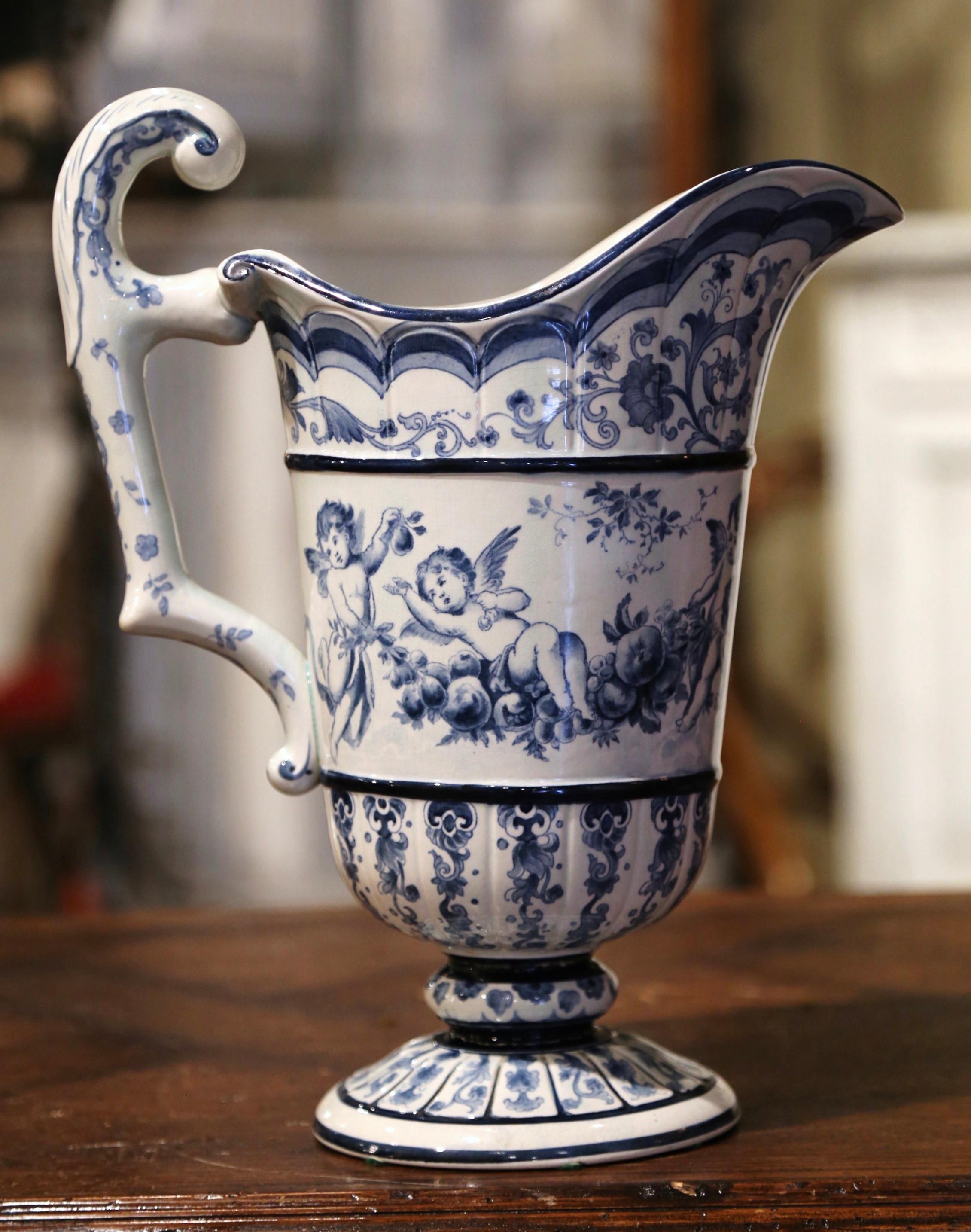 This elegant antique water pitcher was crafted in France, circa 1960. The carafe stands on a round base and is dressed with an elaborate side handle over a wide mouth and pour spout. The vase is decorated throughout with hand painted floral and