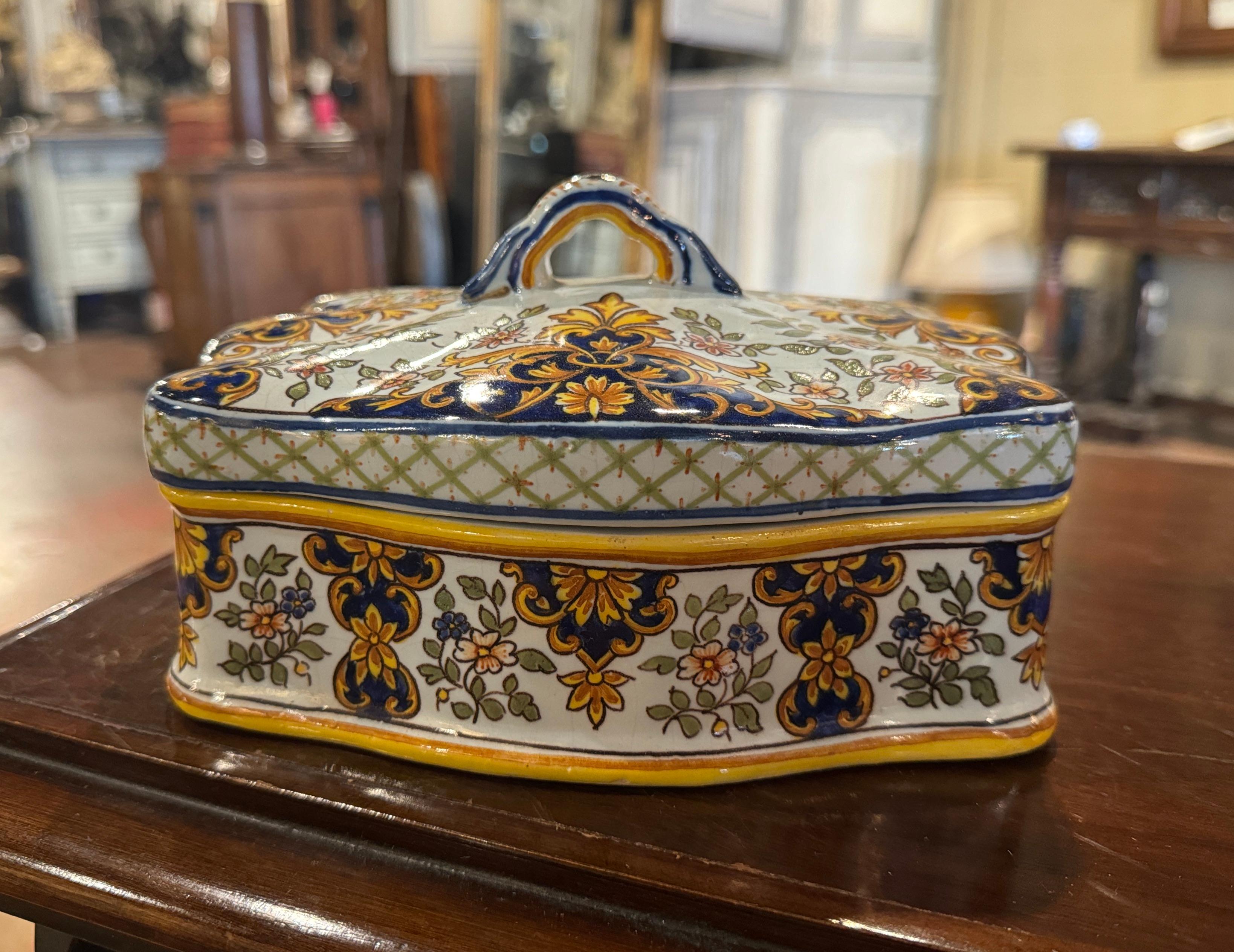 Keep your valuable in this elegant, porcelain jewelry. Crafted in Normandy, France, circa 1950, the antique box is  rectangular in shape with scalloped edges and dressed with a top handle on the detached lid. The casket features hand-painted decor