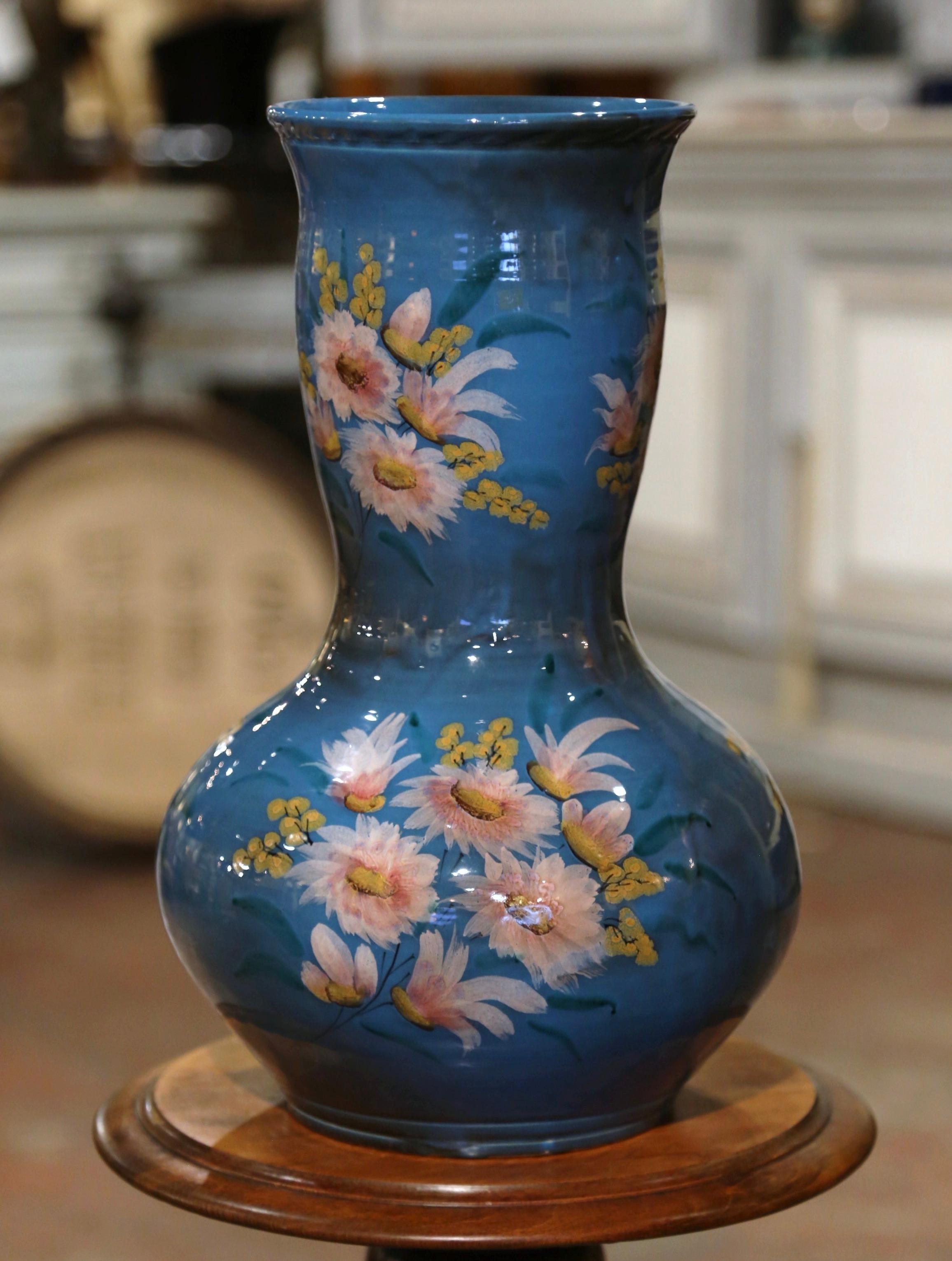 Dress a table, a console or cabinet with this large and colorful antique vase. Crafted on the French Riviera, southern France circa 1950, the elegant vessel is round in shape with a long neck, and features hand painted floral motifs throughout. The