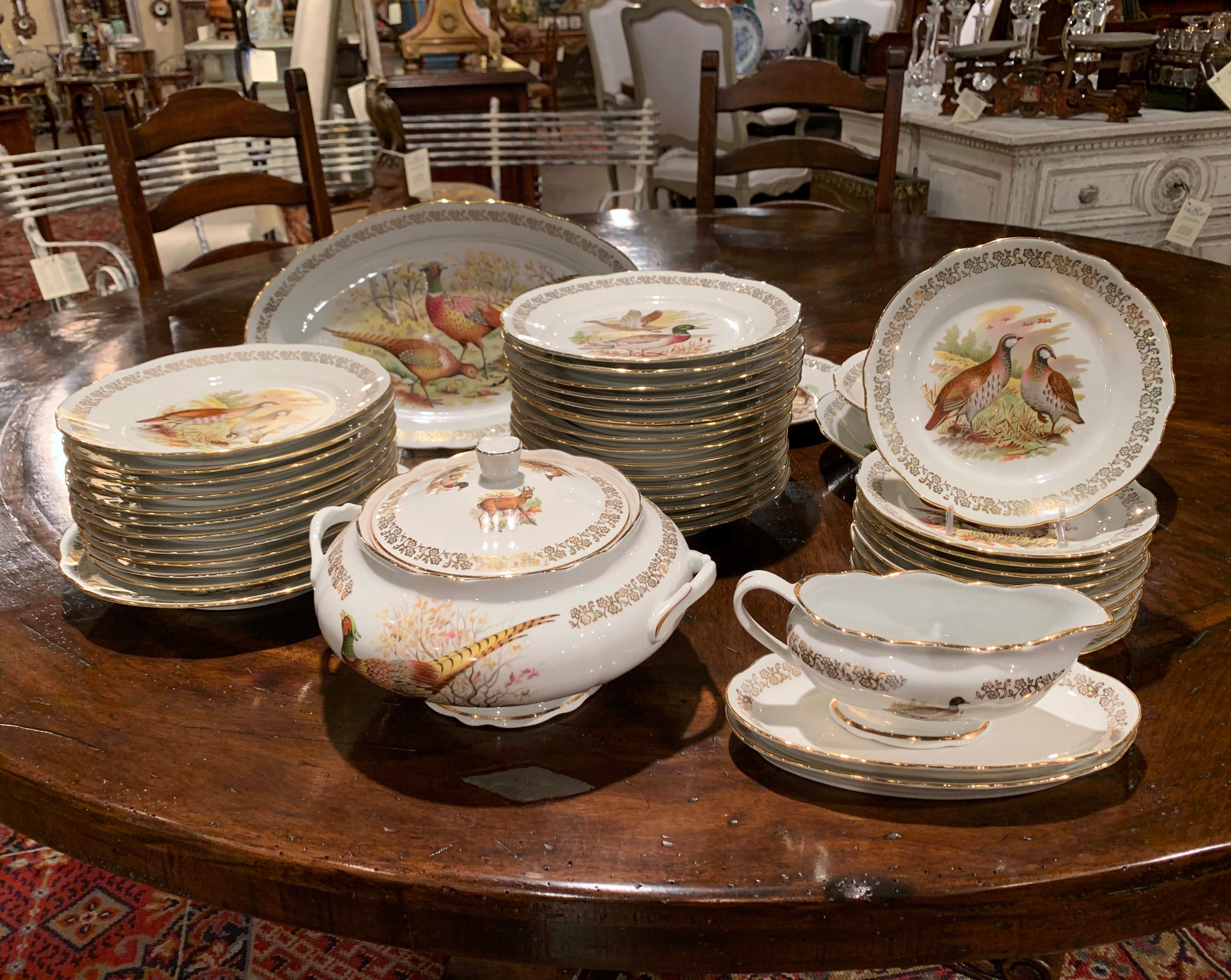 Decorate a dining room table with this exquisite porcelain service set of 46 pieces ; crafted in France circa 1960, the set features hand painted hunt motifs with gilt trim. The motifs include rabbit, deer, grouse, duck, boar, and much more. Each