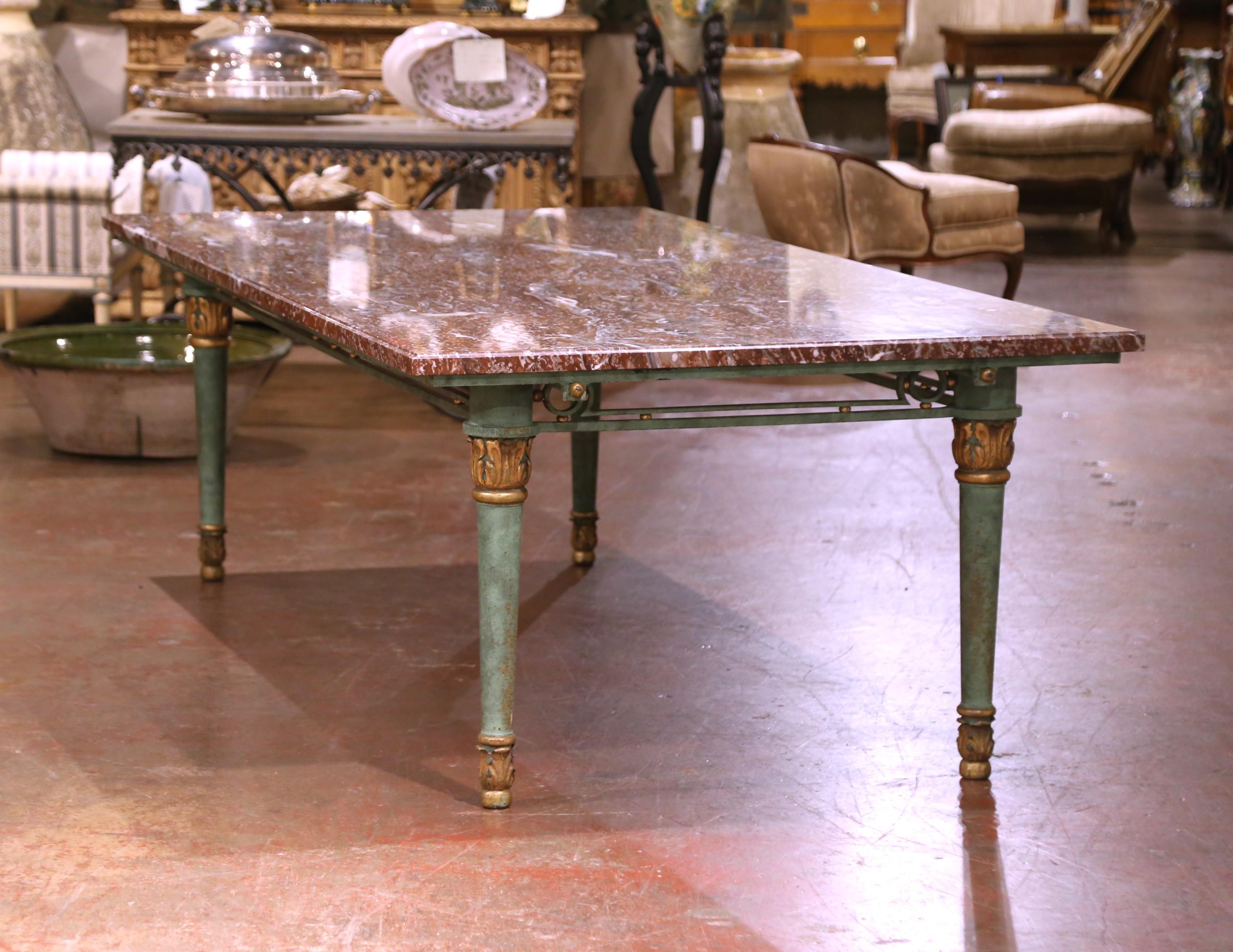 Rehaussez votre espace de conférence ou de salle à manger avec cette étonnante table française ancienne, fabriquée vers 1960. L'imposant plateau rectangulaire est sculpté dans un marbre rouge richement veiné, affichant des tourbillons spectaculaires