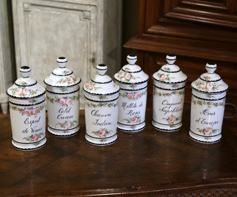 Decorate a master bathroom, a bathtub or a kitchen cabinet with this elegant set of pharmaceutical jars. Created in Limoges, France, circa 1960 by the Atelier Sillonnet, each colorful porcelain pot dressed with a lid, features an apothecary recipe
