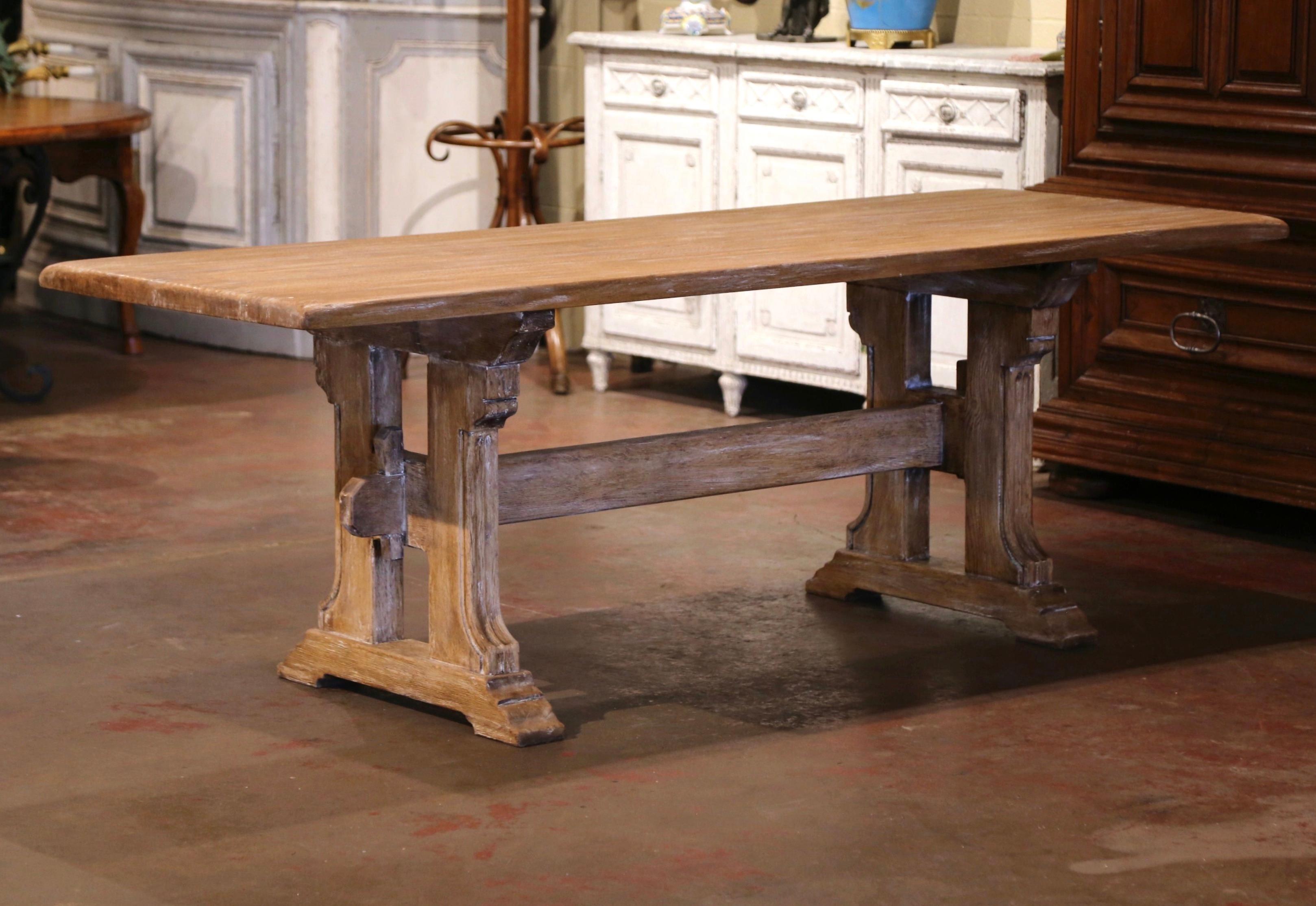 Bring the old world look into your dining or breakfast room with this elegant antique dining table. Crafted in France circa 1960 from reclaimed oak timber, the seven foot table stands on two hand carved baluster form supports ending with a molded
