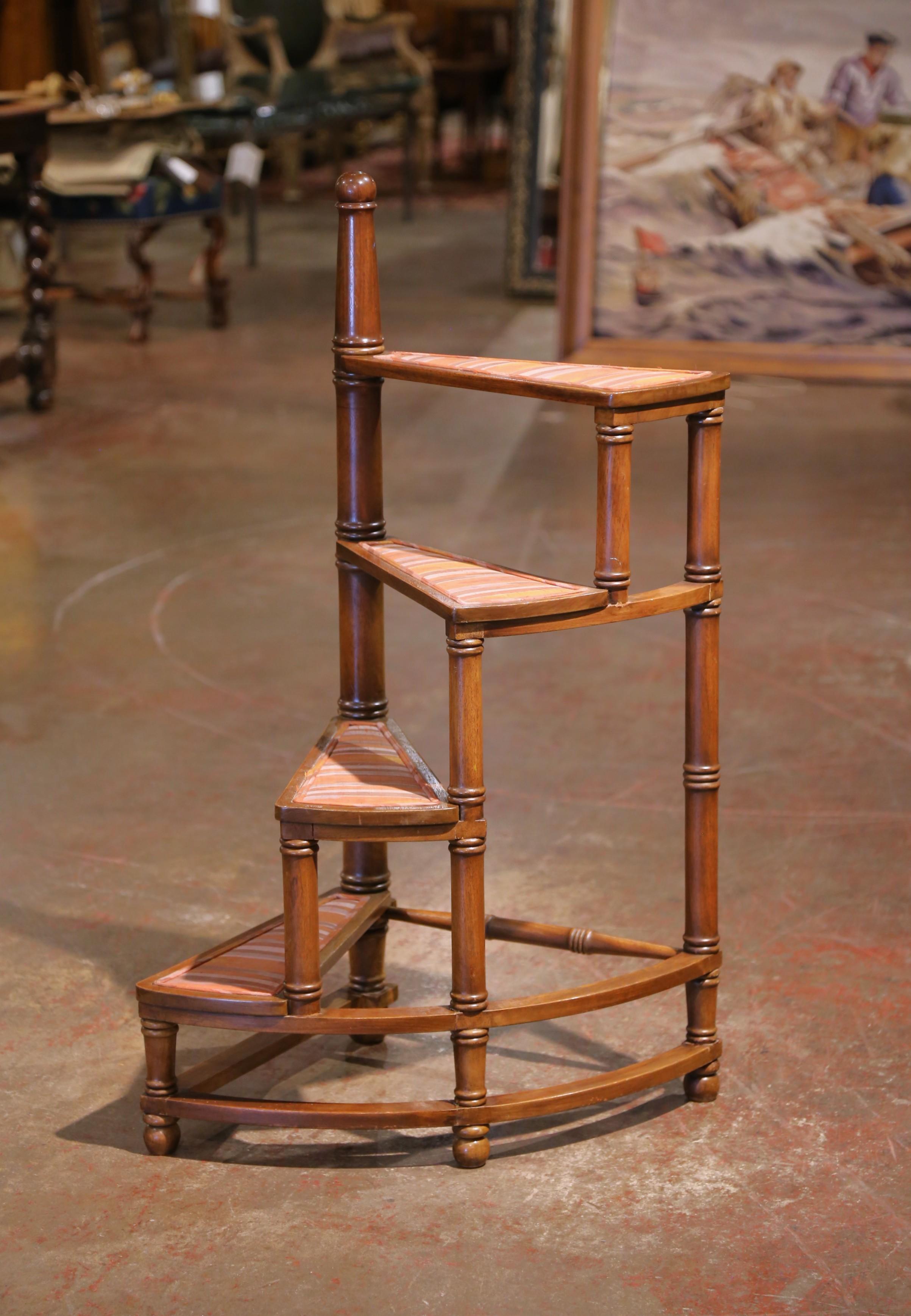 Elevate your interior with this refined mid-century French library ladder in the Louis XIII style. Crafted circa 1960, the piece is made of solid walnut and features a graceful carved spiral design with four triangular steps, each upholstered in