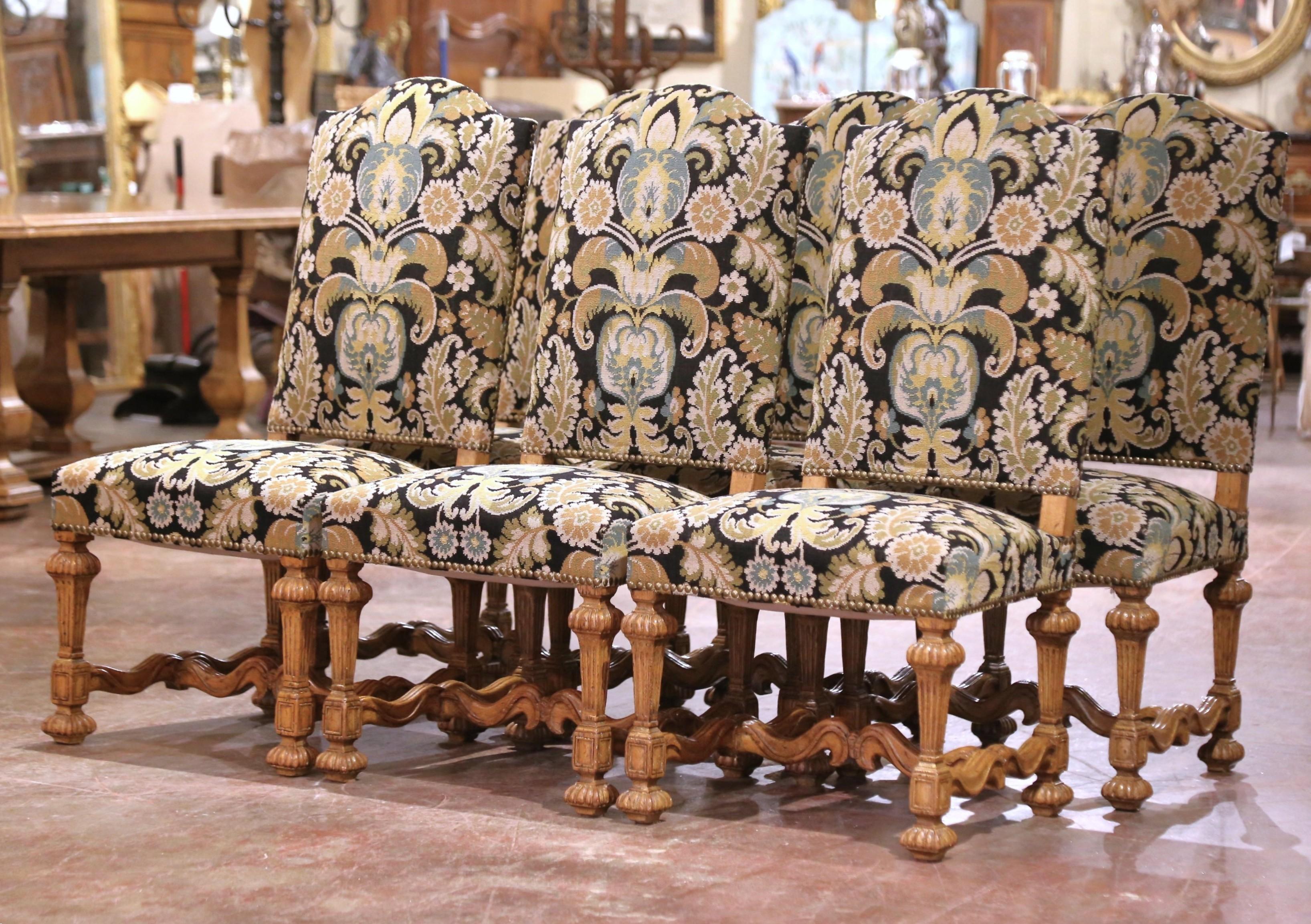 This elegant suite of six side chairs was crafted in France, circa 1960. Each generously scaled chair features a tall, arched and pitched back, a wide seat, and tapered, fluted legs joined by a bottom stretcher for added stability. Inspired by Louis