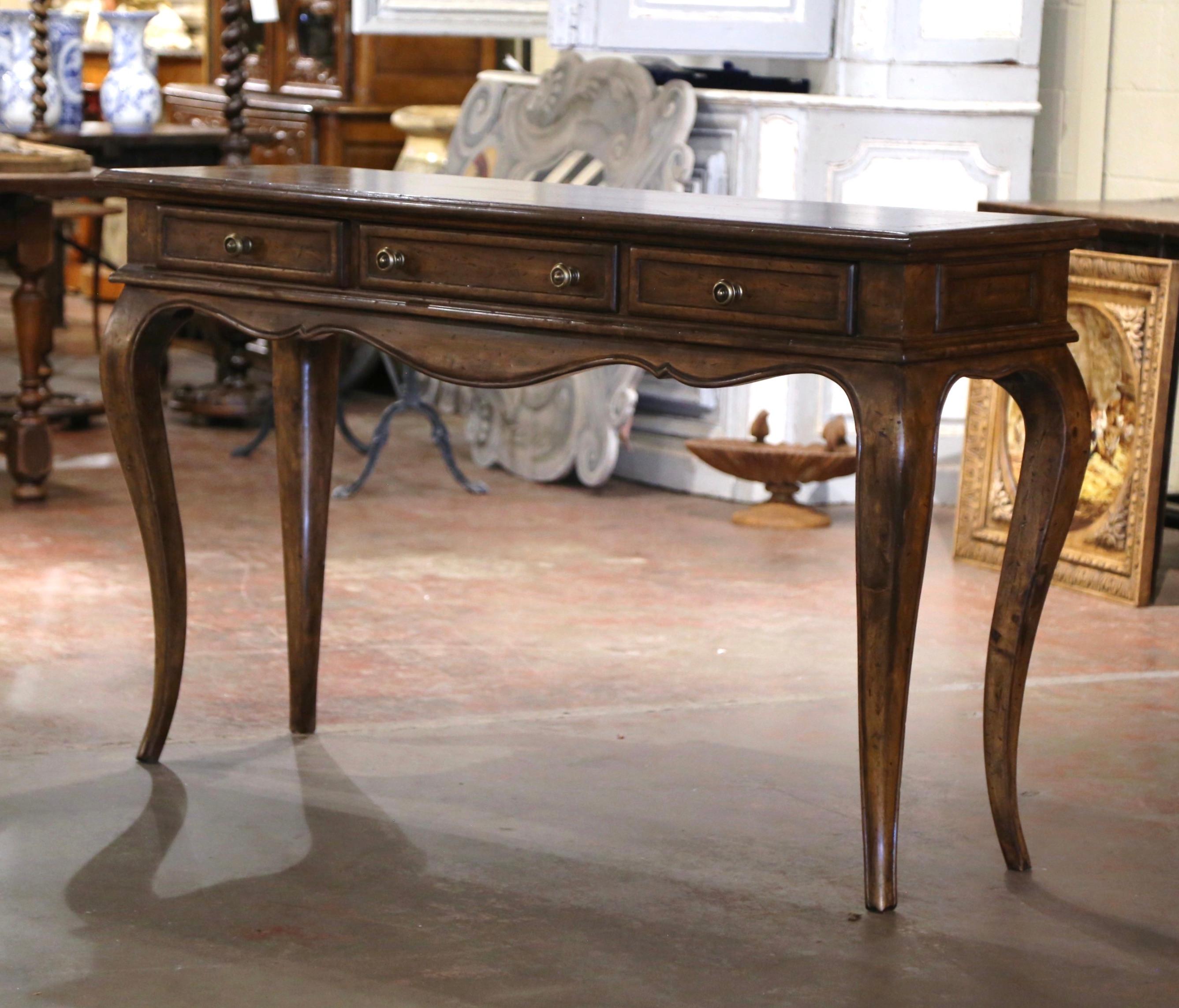 Place this elegant vintage walnut console table behind a sofa or against a wall. Crafted in France circa 1960 and over five feet long, the sofa table sits on cabriole legs over a scalloped apron, evoking the Louis XV style, known for its flowing
