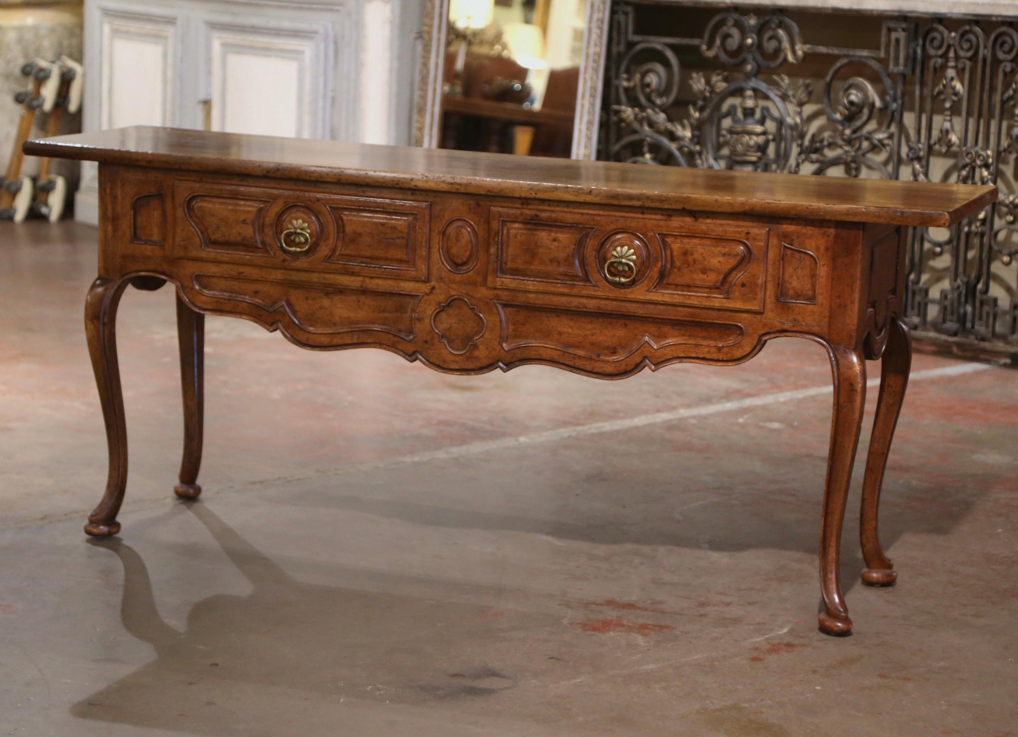 Place this elegant vintage walnut console table behind a sofa or against a wall. Crafted in France circa 1960 and over five feet long, the sofa table sits on cabriole legs ending with hoof feet over a scalloped apron, evoking the Louis XV style,