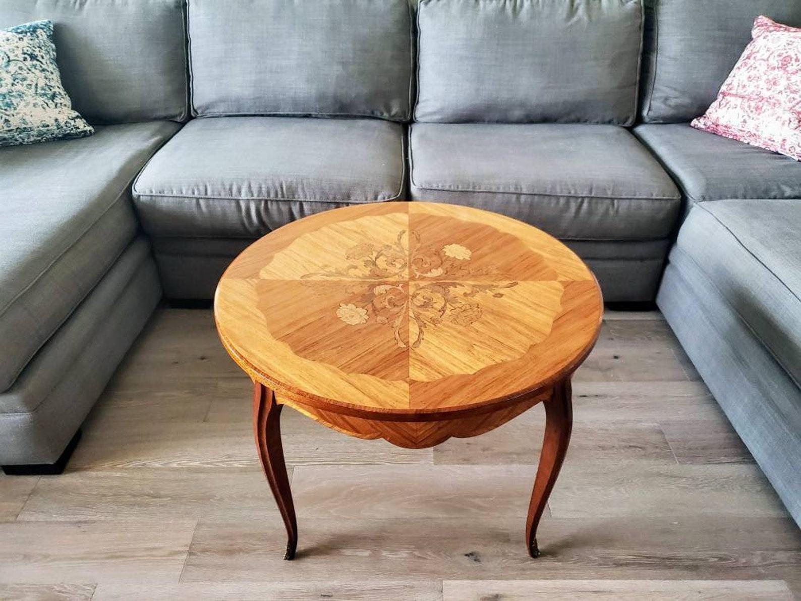 An elegant round occasional table, handcrafted in France in the mid-20th century, having a solid wooden frame with exquisitely inlaid circular tabletop with fanciful scrollwork, floral and fiolate marquetry motif, fabulous diamond parquetry and fine