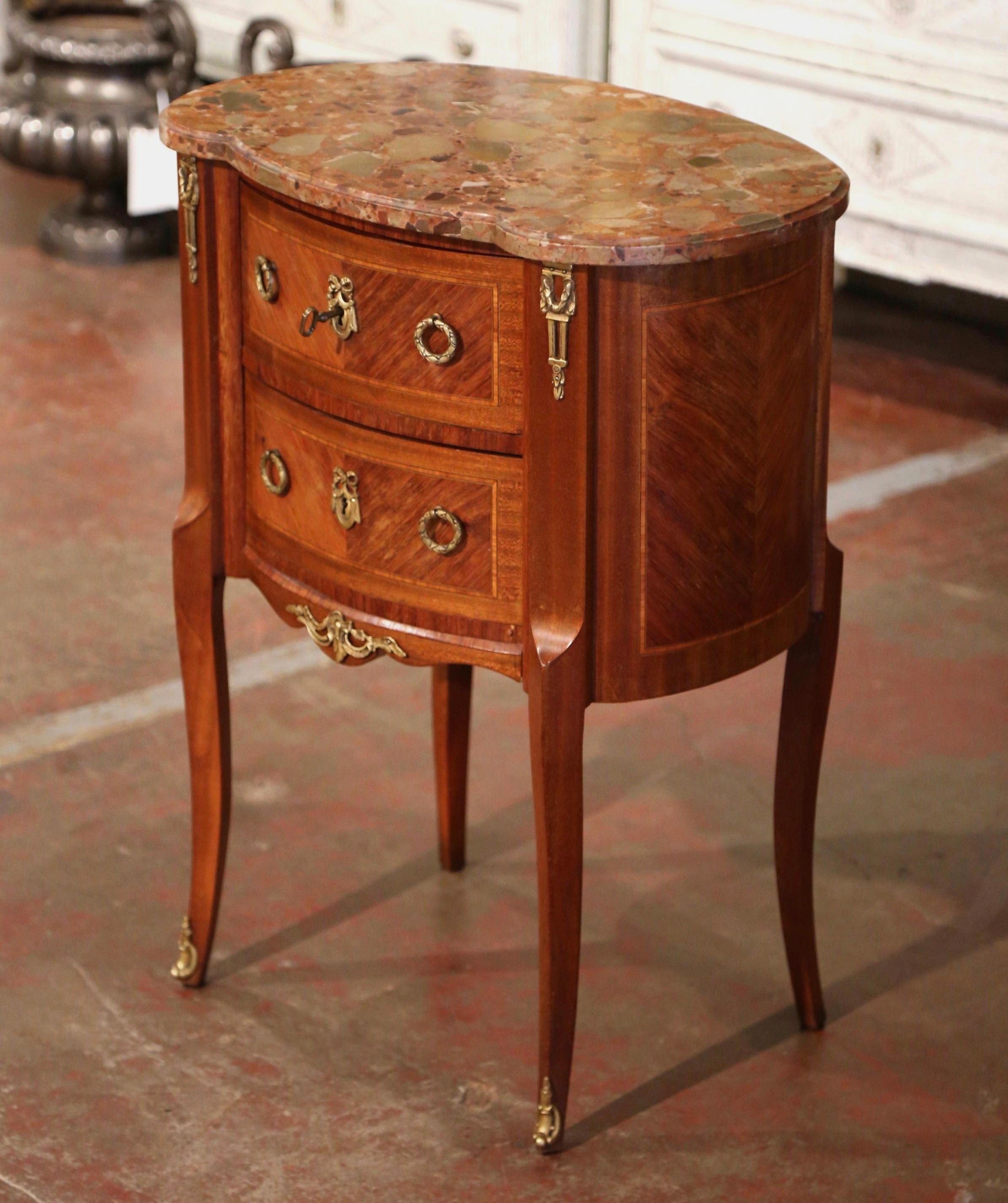 This elegant, kidney-shaped fruitwood antique commode was crafted in France, circa 1950. The commode sits on cabriole legs ending with bronze sabot mounts over a scalloped apron decorated with a bronze mount. The bow front features two drawers
