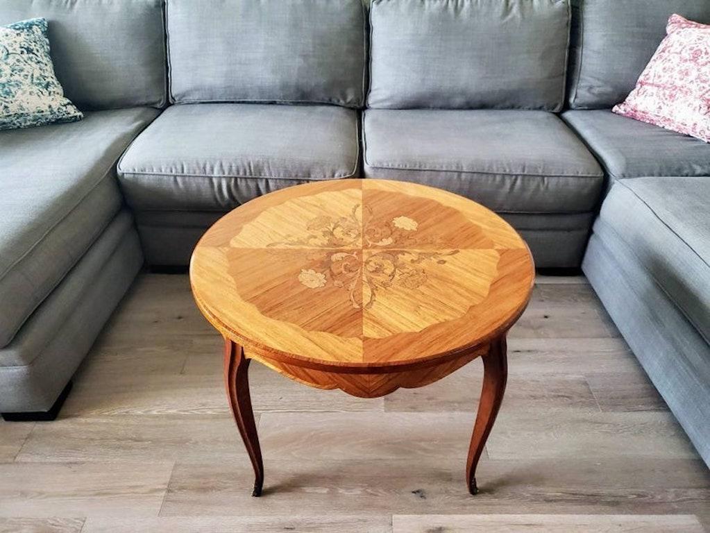 An elegant round occasional table, handcrafted in France in the mid 20th century, having a solid wooden frame with exquisitely inlaid circular tabletop with fanciful scrollwork, floral and fiolate marquetry motif, fabulous diamond parquetry and fine