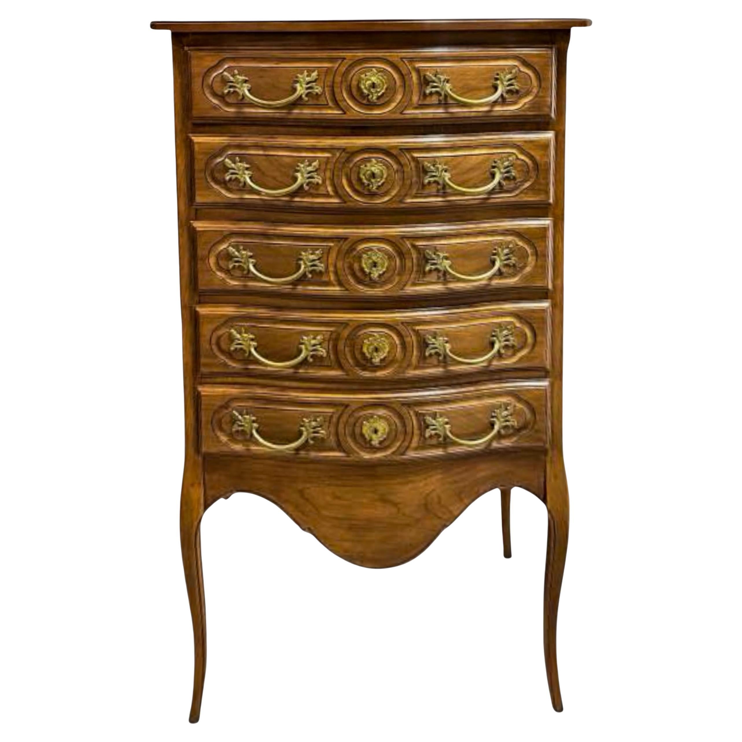 This is a wonderful large scale lingerie chest manufactured by Hickory Manufacturing in the 60s. It has dovetail construction and beautiful gilt bronze hardware. It is in a beautiful fruitwood on elongated legs. 