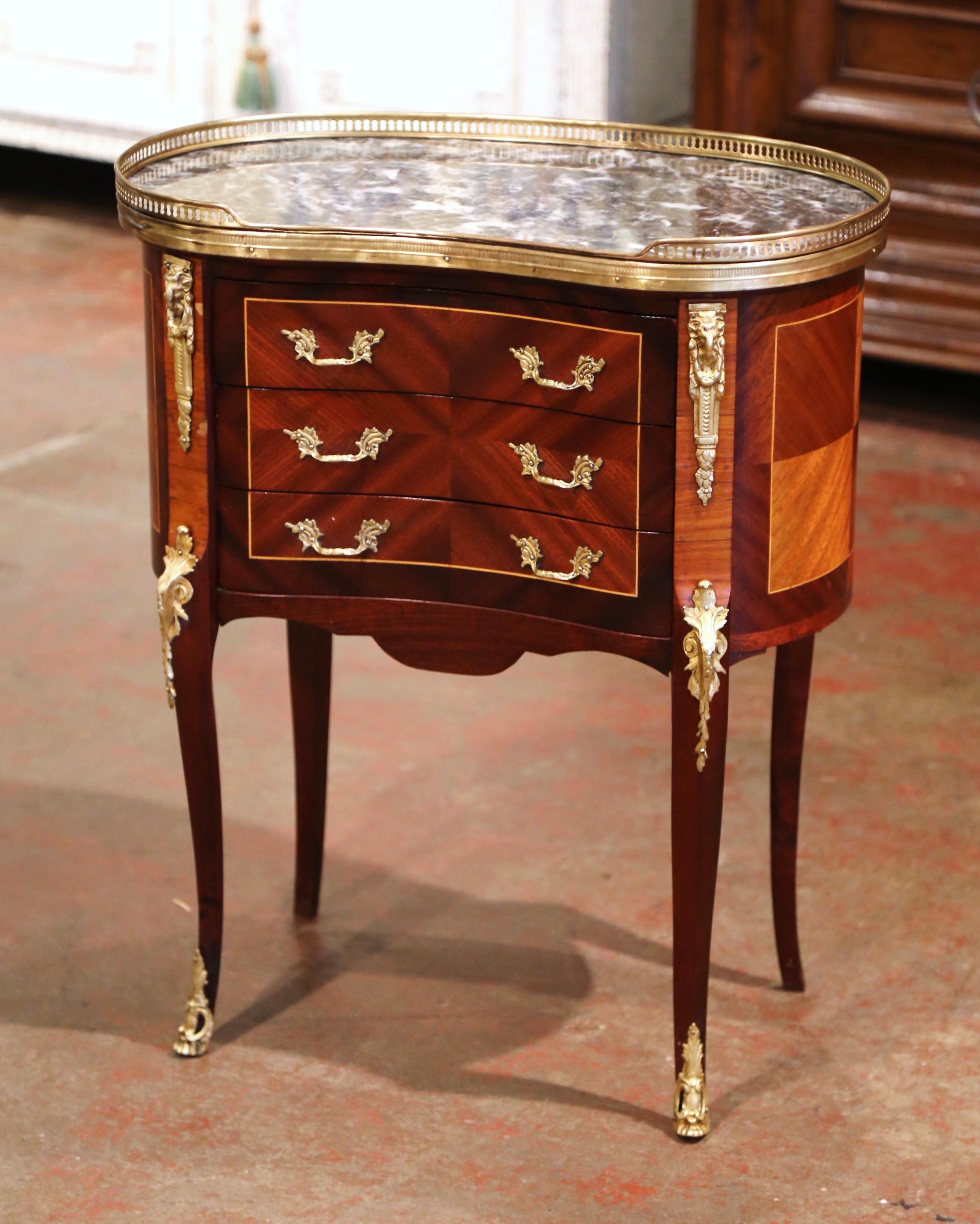 This elegant, kidney-shaped fruitwood antique chest was crafted in Paris, circa 1950. The petite commode sits on cabriole legs decorated with acanthus leaf mounts at the shoulder, and ending with brass sabot feet; it features three drawers across
