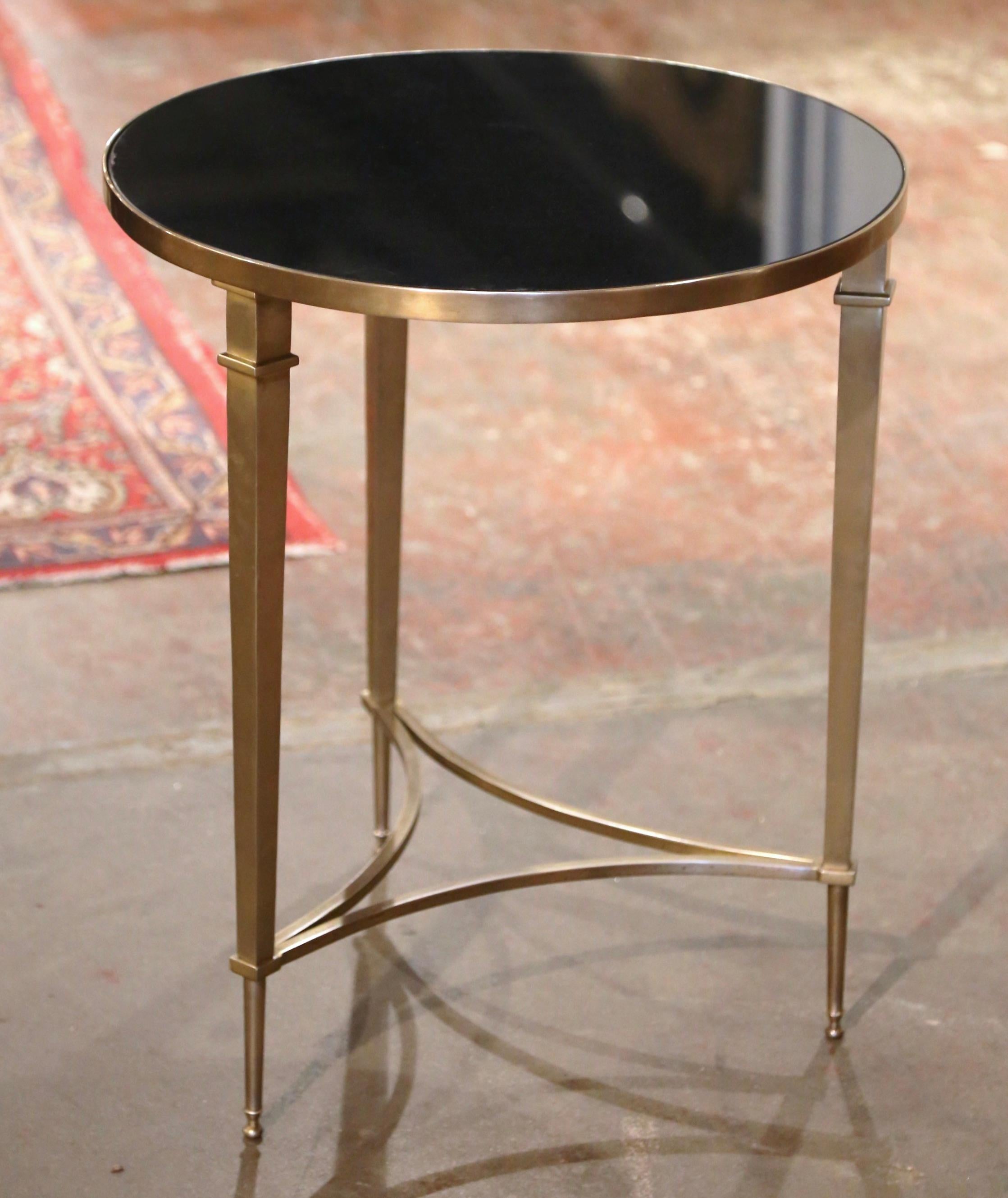 Decorate a living room with this elegant neoclassical antique gueridon table. Created in France circa 1950, and round in shape, the table is supported by three slender tapered legs ending with small cap feet. The bottom is further embellished with a
