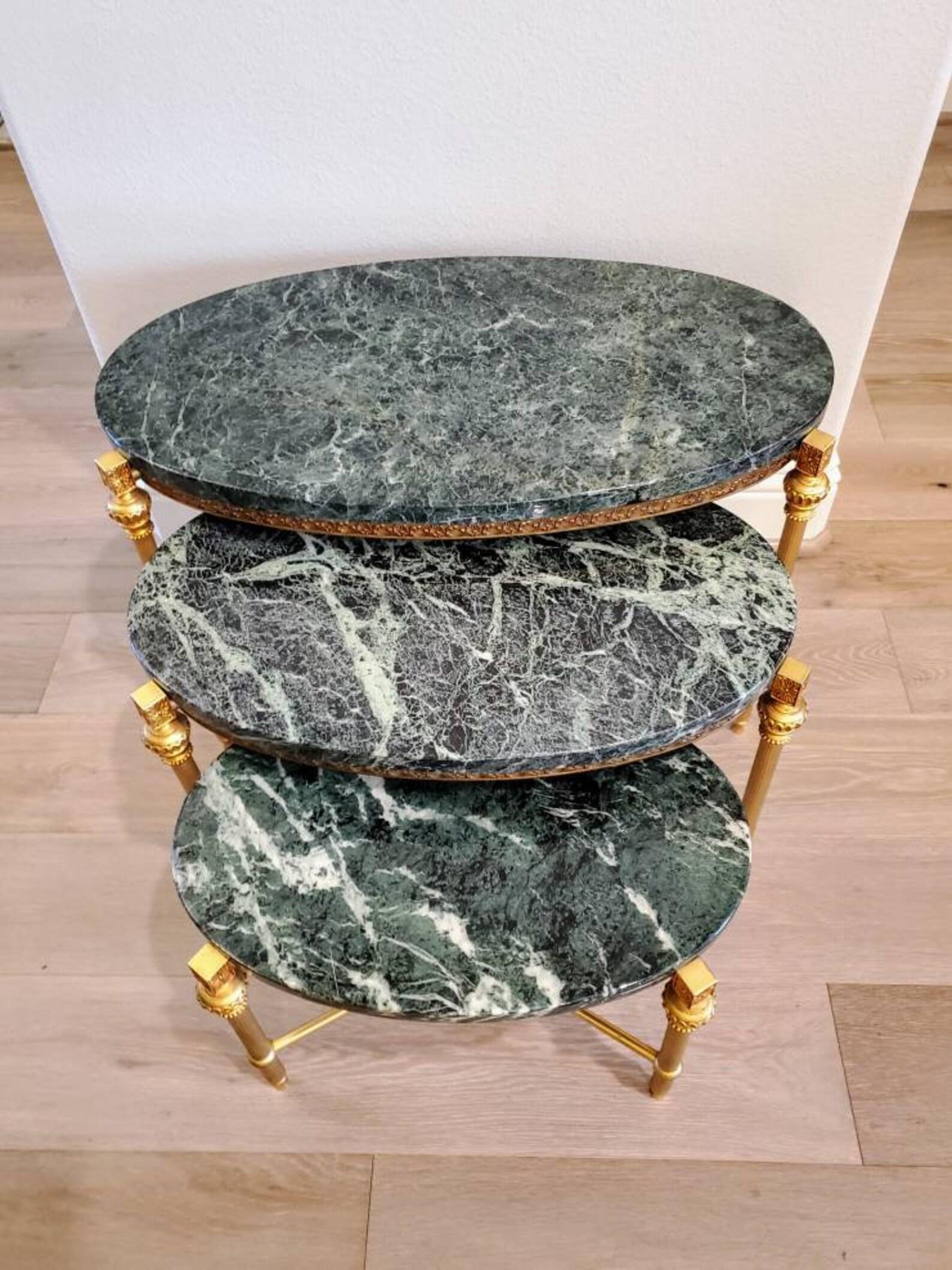 A magnificent set of three French mid 20th century gilded brass marble top nesting tables attributed to Maison Baguès for Parisian design firm Maison Jansen. 

Finished in luxurious Louis XVI taste, each table graduated in size, having a striking