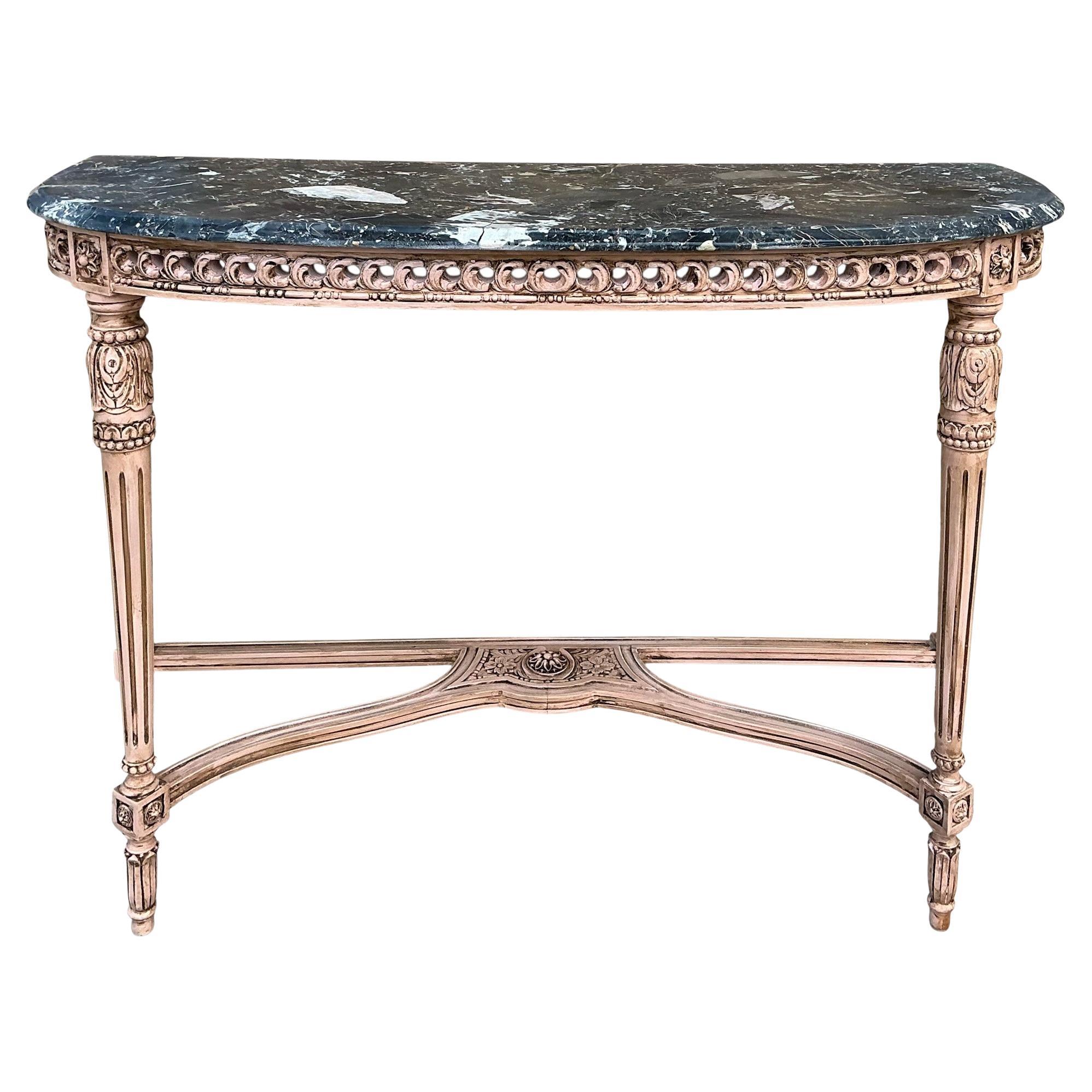 This is a lovely French Louis XVI style carved console table with a marble top. The hand painted frame is a blush color with a brown glaze. The marble top is predominantly grey with white veins and flecks of pink. It is unmarked and in very good