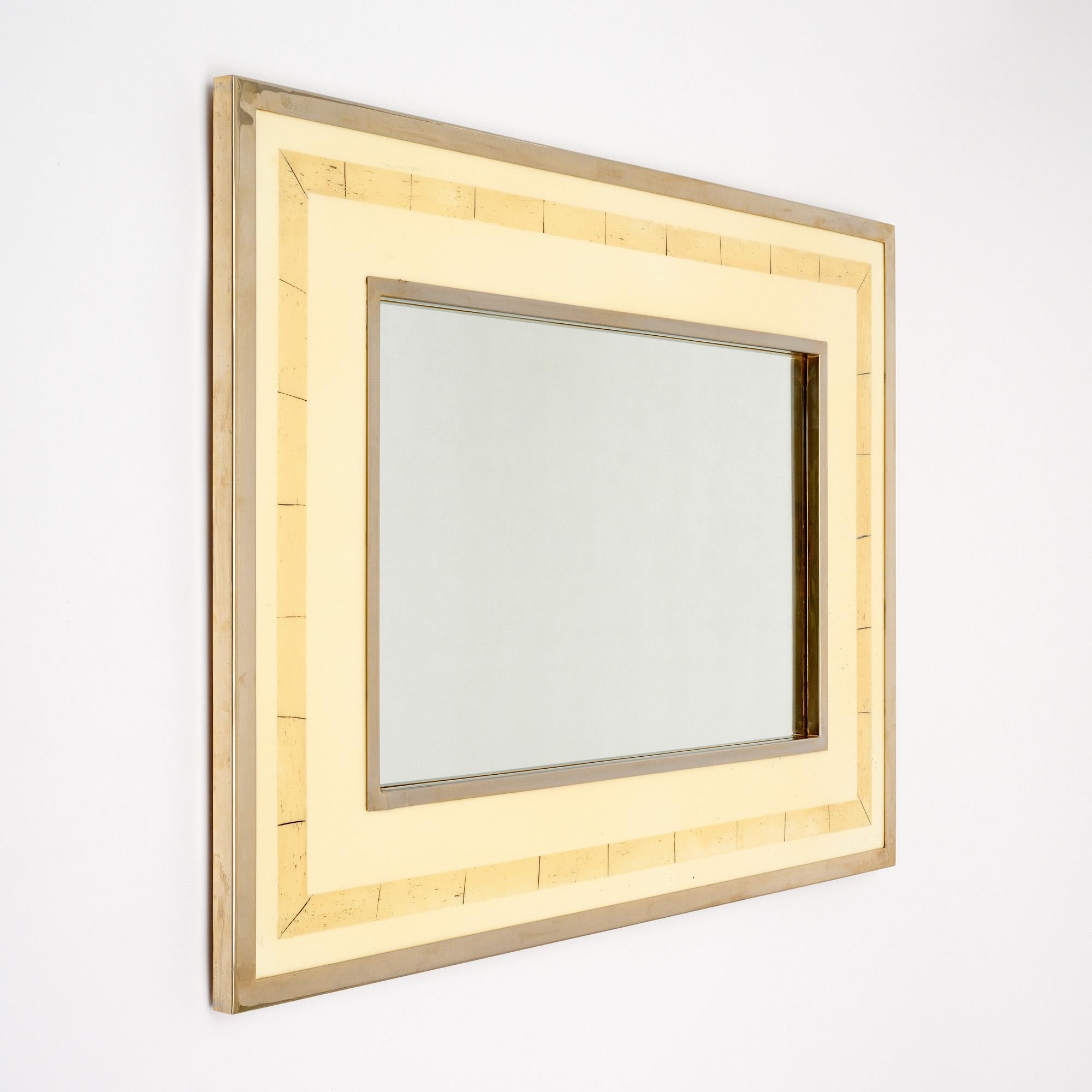 Specchio della metà del secolo scorso realizzato in Francia con una struttura cromata che racchiude la cornice e lo specchio rettangolare centrale. La cornice è realizzata in lucite color avorio con un bordo di bambù stilizzato. Lo specchio centrale