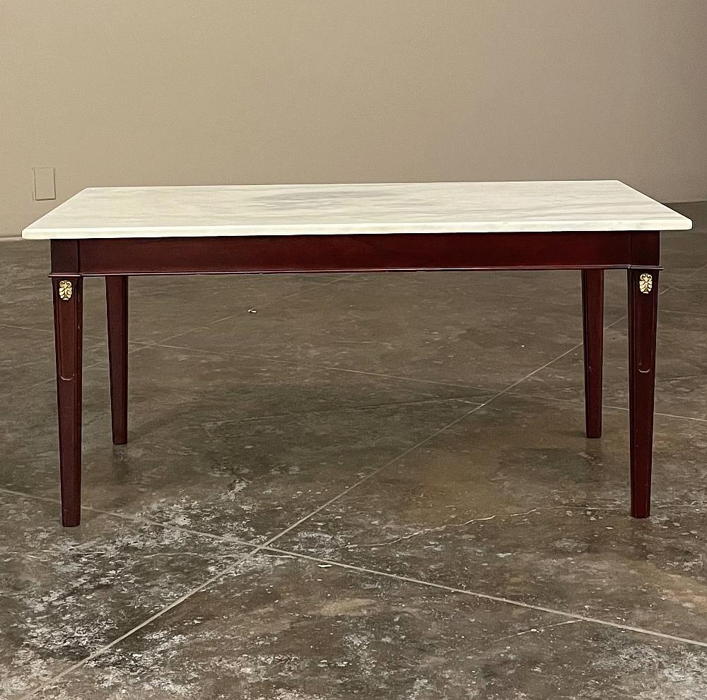 Mid-century French Mahogany Directoire style coffee table with Carrara marble top represents understated elegance in a manner of which the French are internationally known! Tailored, neoclassical architecture defines the style, with clean apron