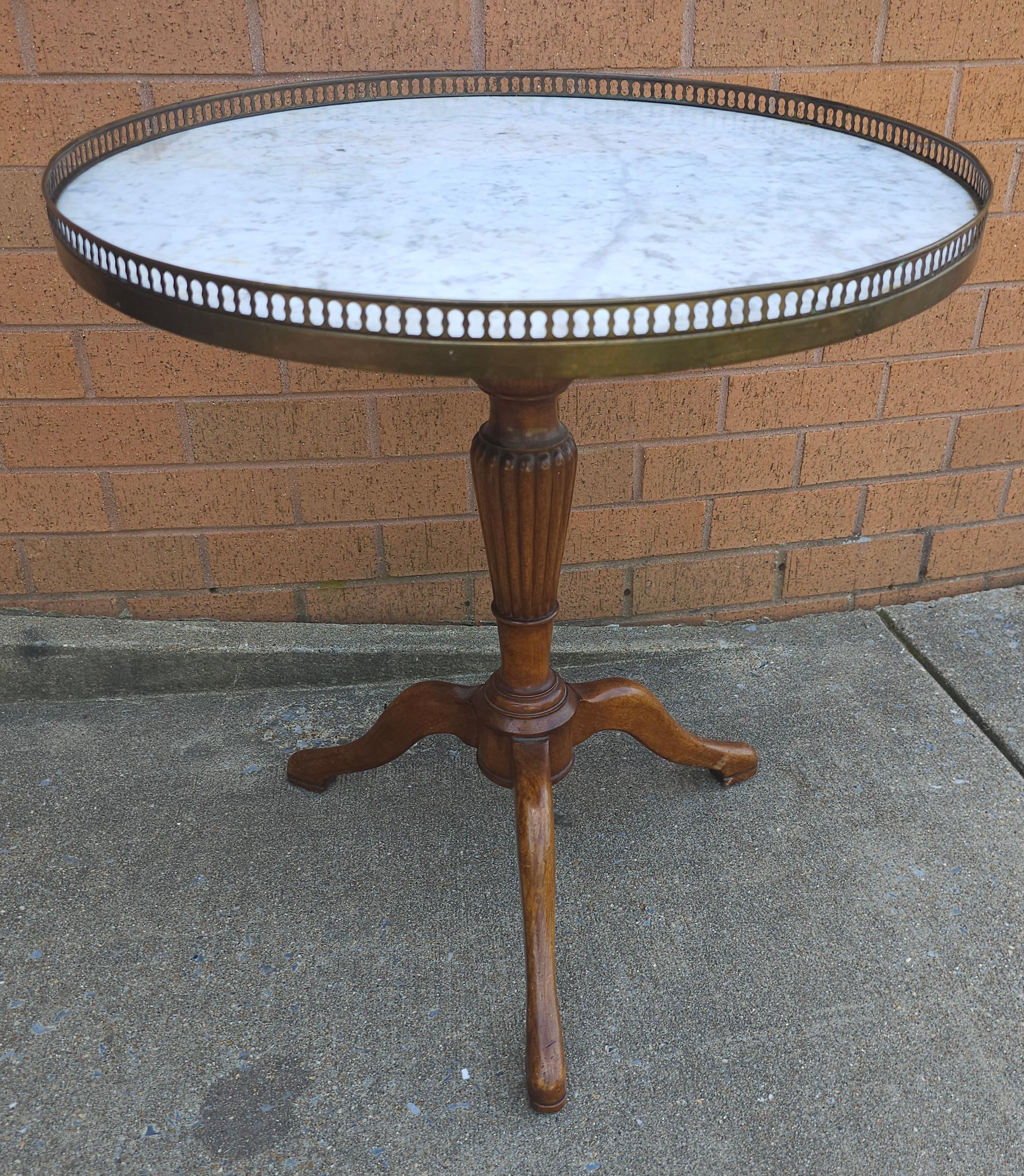 A Mid-Century French Mahogany and  Marble Top Galleried Tripod Pedestal Gueridon Table. Metal brass gallery and Carrera marble top. 