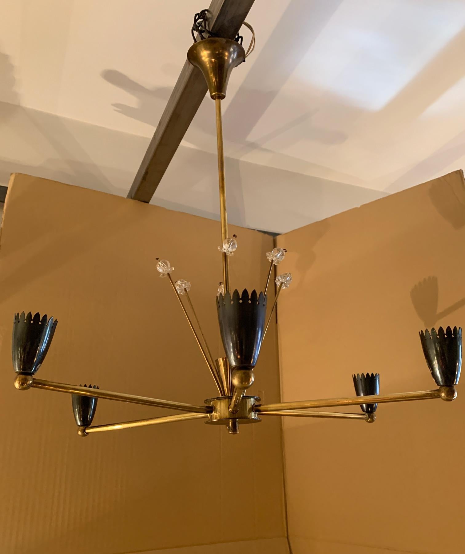 French chandelier, by Maison Arlus, in golden brass, each one finished in the shape of an enameled glass, in the main column it is surrounded by brass rods finished in glass.