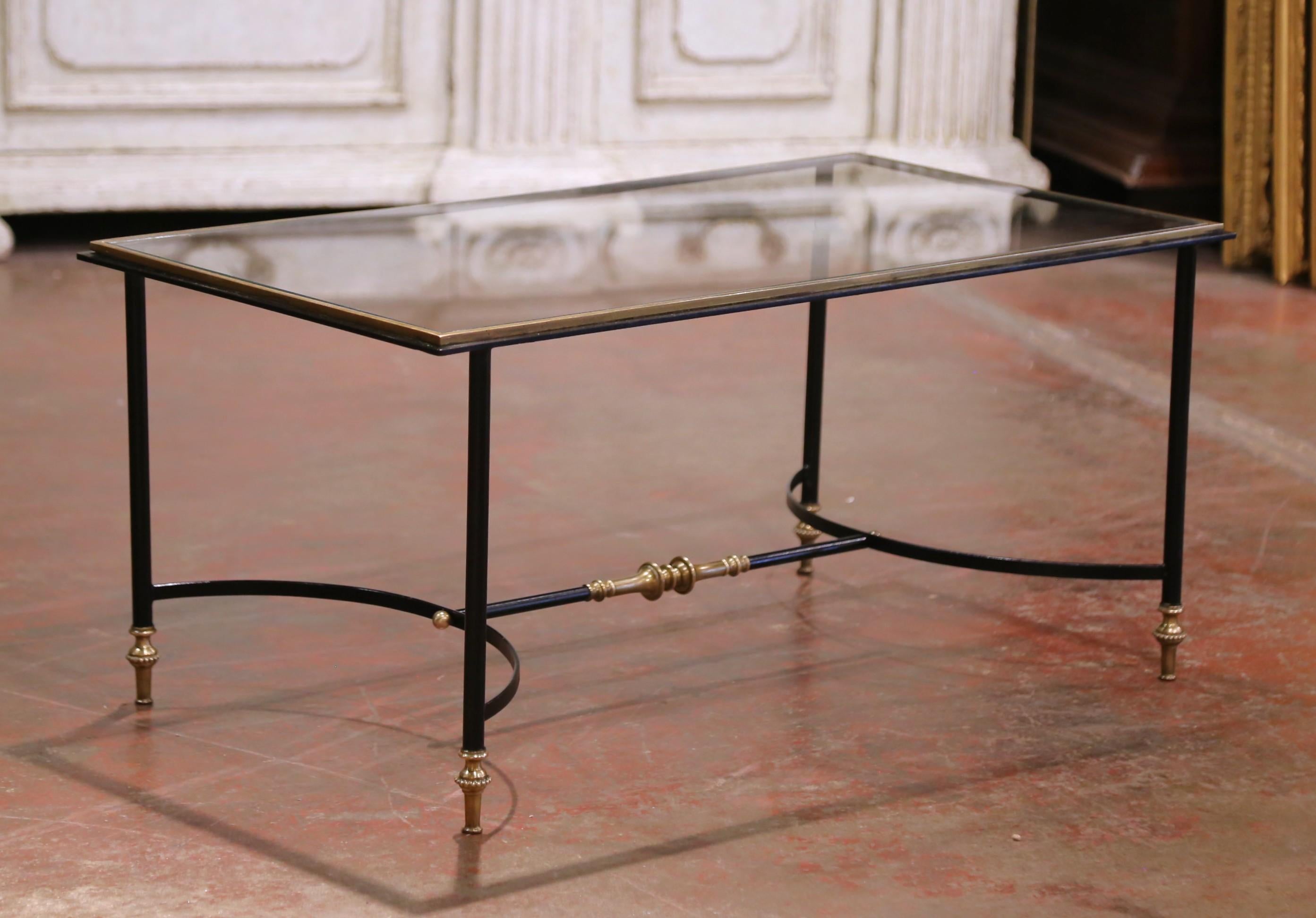 Esta elegante y esbelta mesa de cóctel se fabricó en Francia hacia 1960 y se atribuye a la apreciada Maison Baguès. El diseño presenta un armazón de acero ennegrecido y bronce con un acabado en dos tonos de cañón de fusil y dorado, que ofrece un