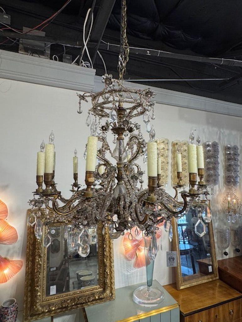 The Mid-Century French Maison Baguès Gilt Bronze and Beaded Chandelier exudes elegance and sophistication. This chandelier showcases intricate detailing and a luxurious gold finish and a plethora of gorgeous crystals, is perfect for adding a touch
