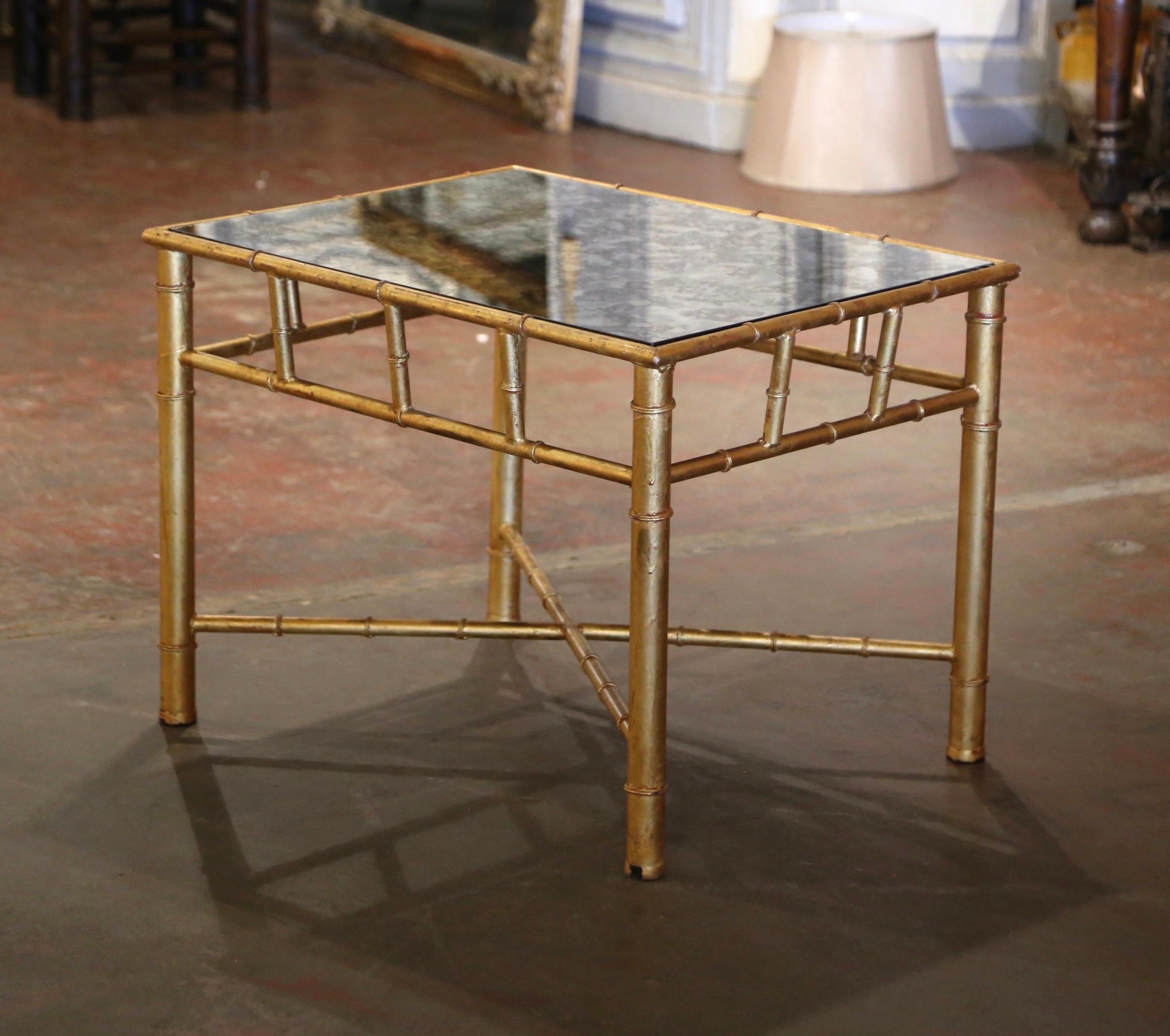 Crafted in France circa 1950, and attributed to Maison Baguès in Paris, this elegant brass table is both useful and stylish. The faux bamboo table exudes elegance and sophistication; dressed with a sleek smoked glass top, the table is framed with