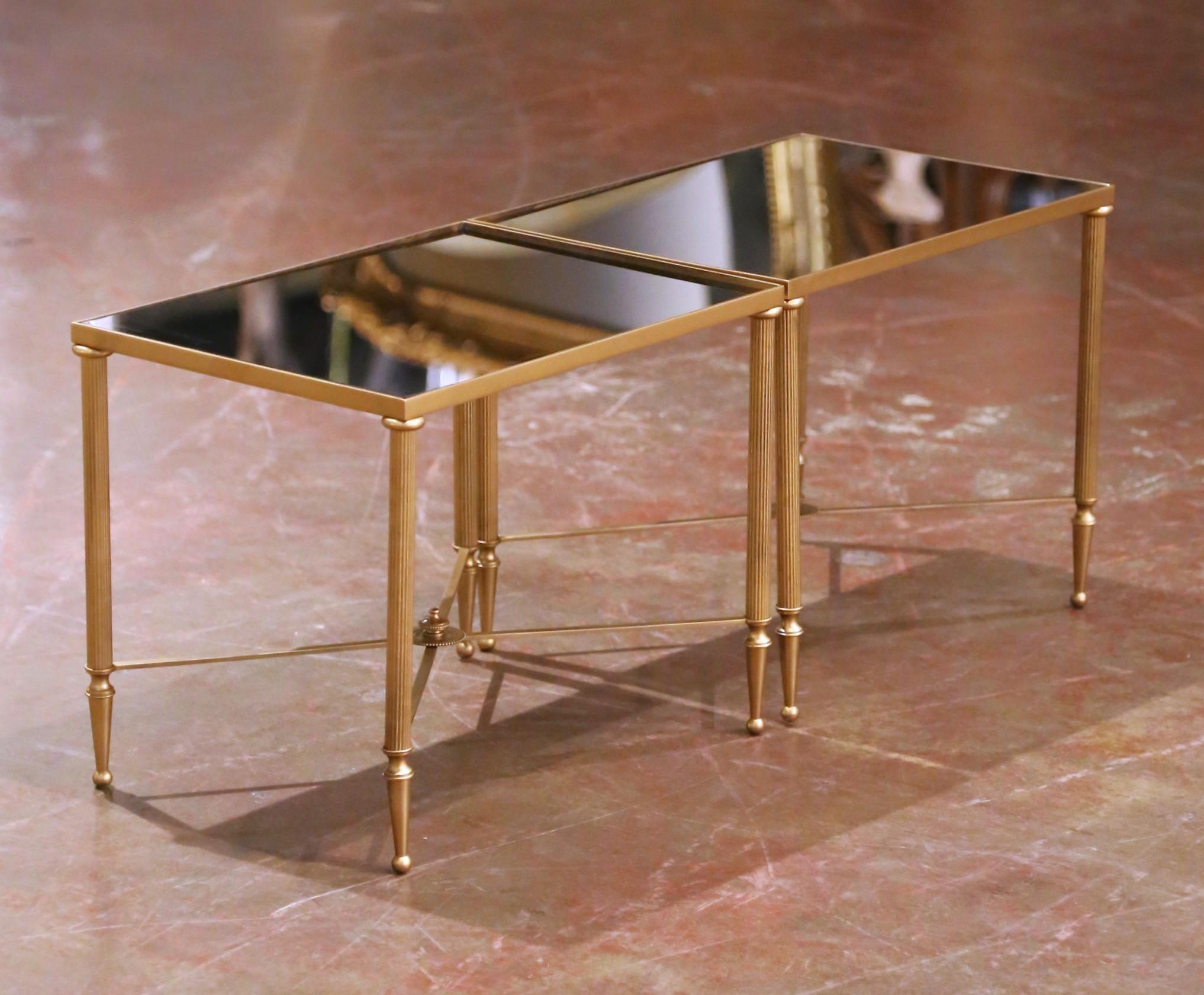 Conçue en France vers 1960, cette paire de tables gigognes raffinées du milieu du siècle est exécutée à la manière de la Maison Baguès, le célèbre atelier parisien réputé pour ses luminaires de luxe et son travail du métal finement détaillé. Chaque