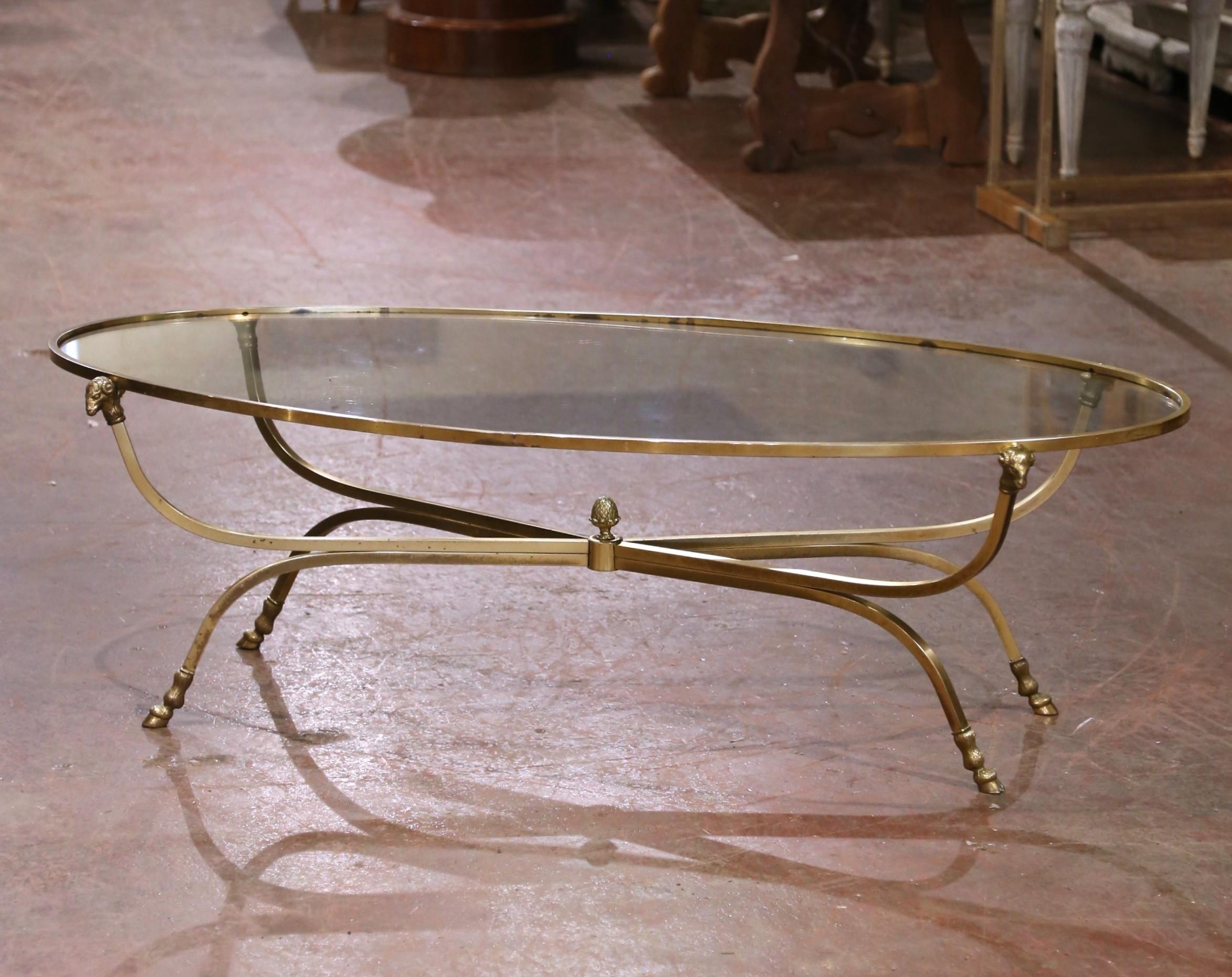 This striking mid-century coffee table was crafted in France circa 1950 and is attributed to the famed Parisian design firm Maison Jansen. The elegant oval frame is executed in gilt bronze and rests on gently curved legs terminating in finely cast