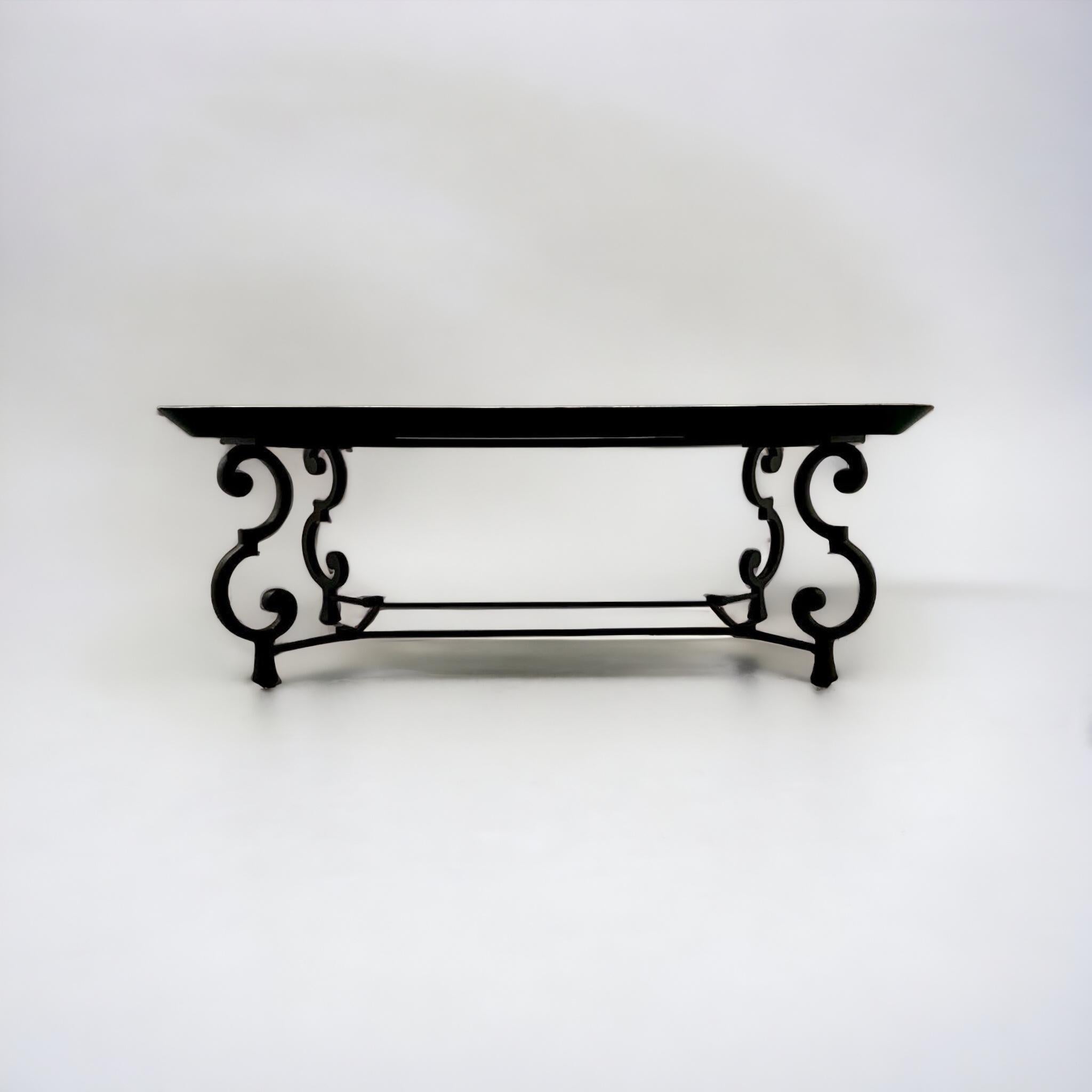 Il s'agit d'une table basse en bois et en fer de la Maison Ramsay du milieu du siècle, peinte à la main, avec un décor de peinture de style tole. Le plateau en bois repose sur une base en fer forgé à volutes. Il est en très bon état.
