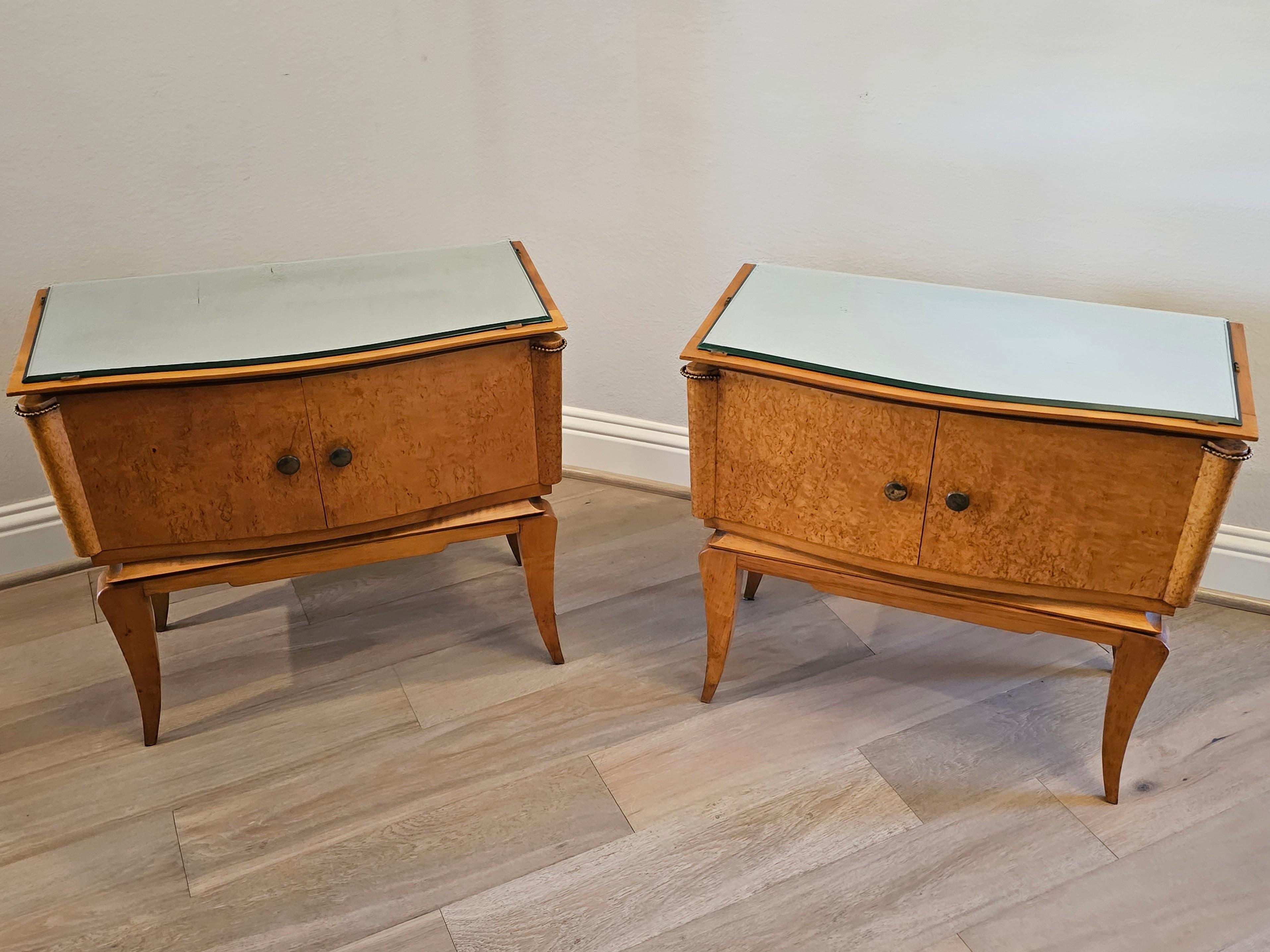 A fabulous pair of original French Modernist burlwood bedside cabinets (nightstands or end tables). circa 1950s/early 1960s

Each retaining the original shaped mirrored top with beveled edge, over conforming solid wood case in richly figured