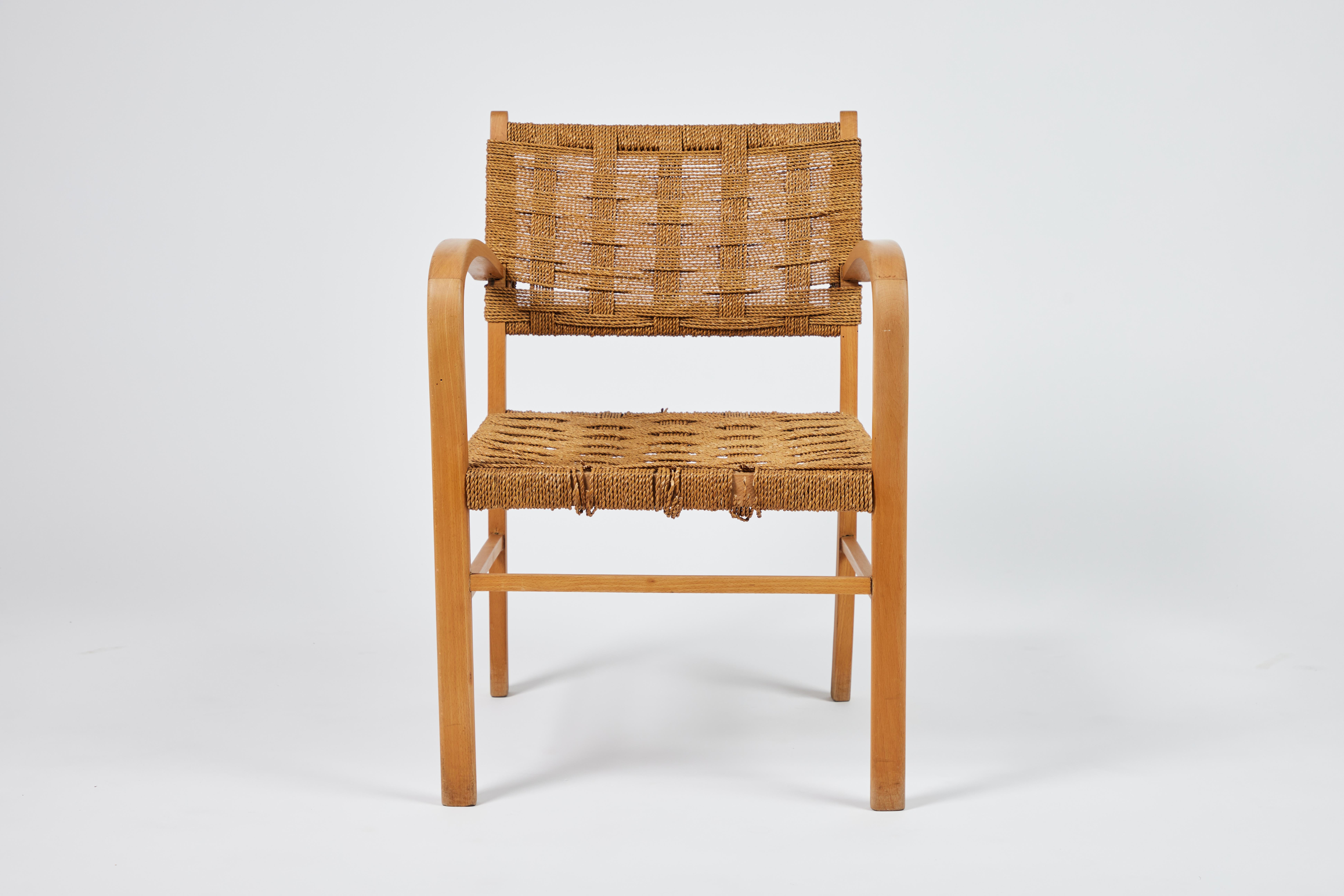 Midcentury French oak arm chair with curved, sculptural arms. Woven seat and back supports are comprised of groups of 8 thin ropes form each 
