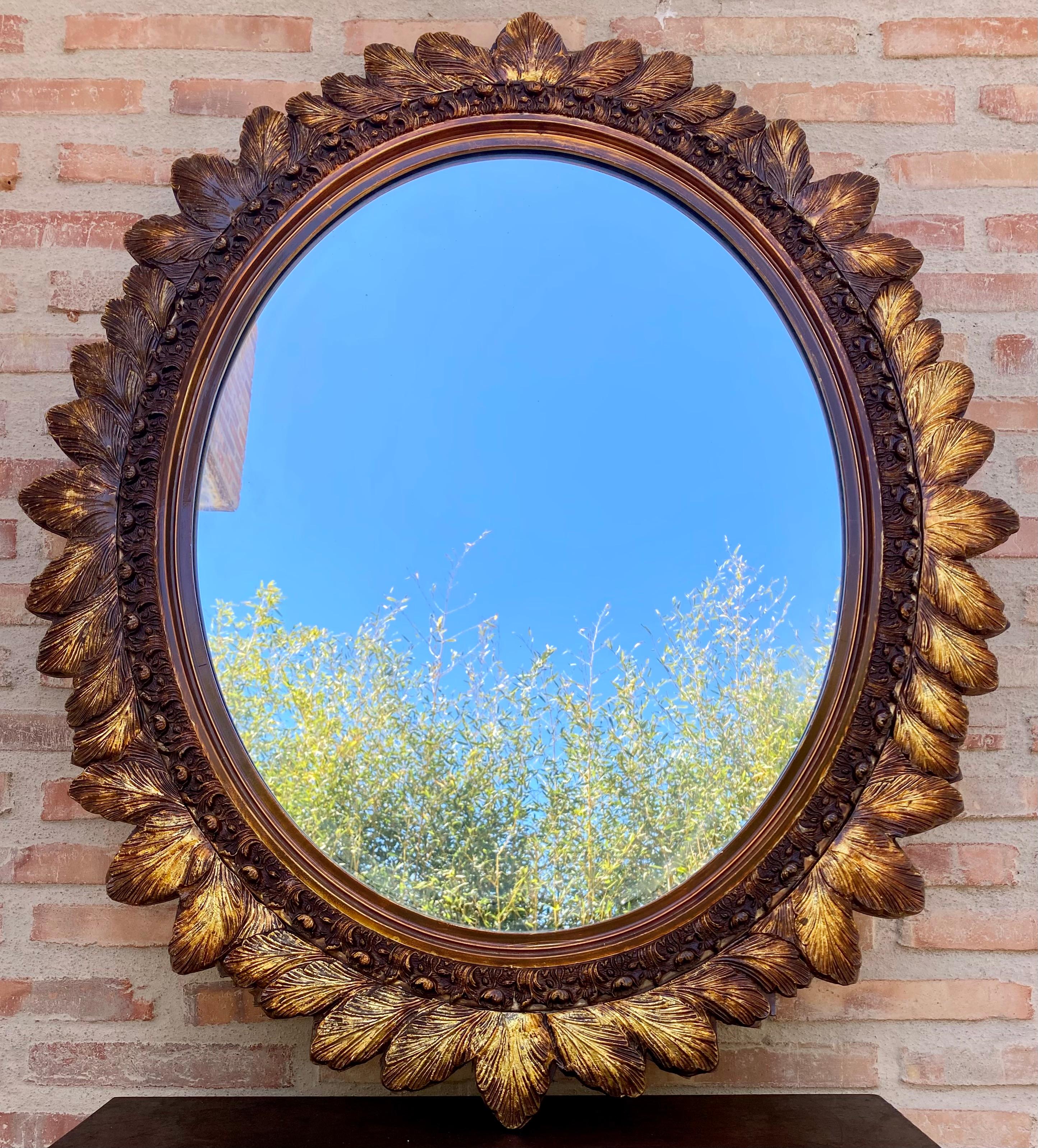 A beautiful large oval mirror in a gold decorative frame with flowers from France. The frame is made of wood. The mirror is in very good vintage condition with no damage or cracks to the frame. Original glass. Truly unique piece for every interior!