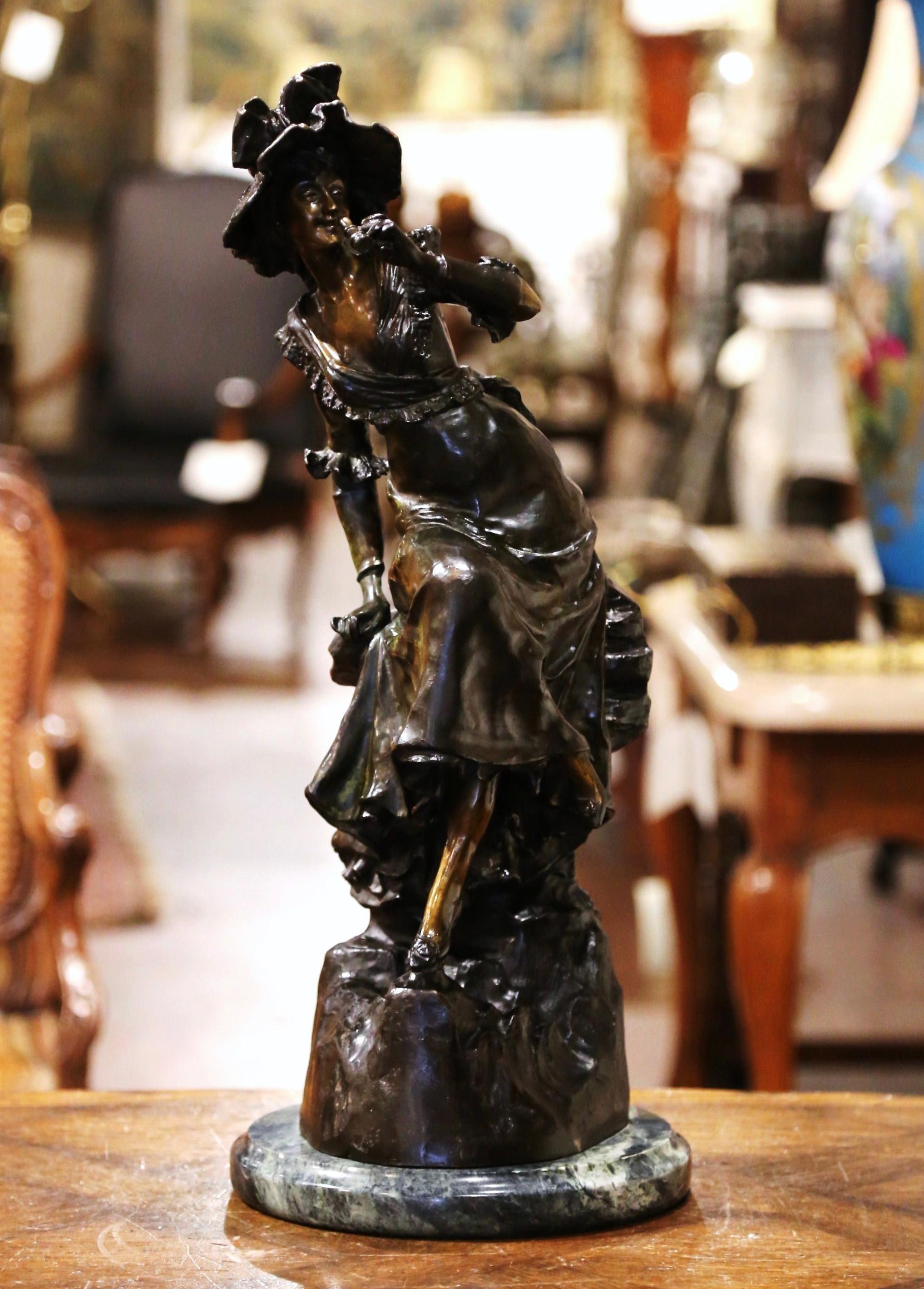 Decorate a study or an office with this elegant bronze sculpture. Crafted in France circa 1950 and resting on a round marble base, the subject depicts a young beauty of fashion sited on a trunk, and holding a pair opera binoculars. The tall lady